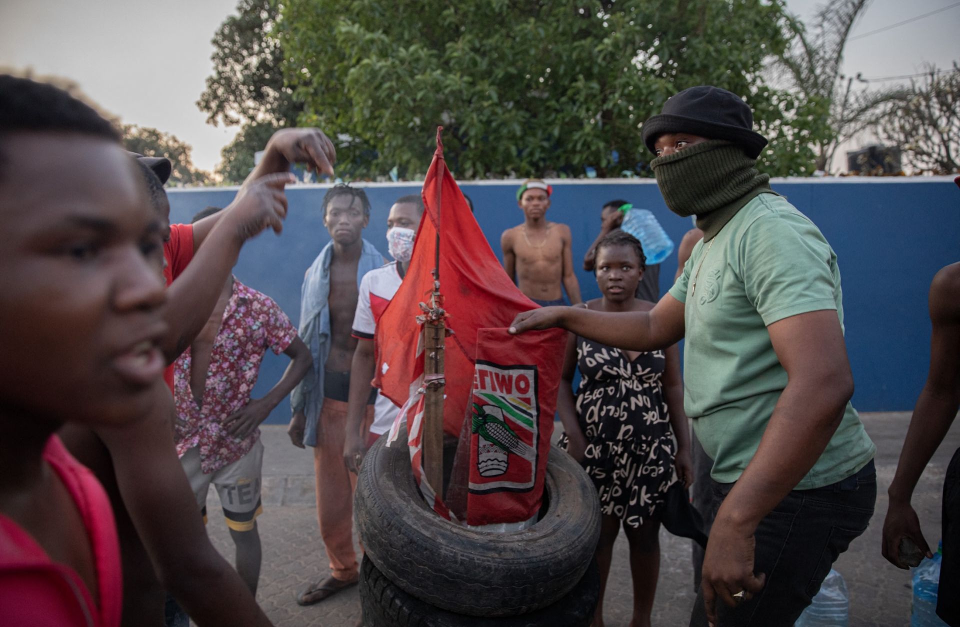 Protesters in Maputo prepare to burn a flag of Mozambique's ruling Frelimo party on Oct. 24, 2024. 