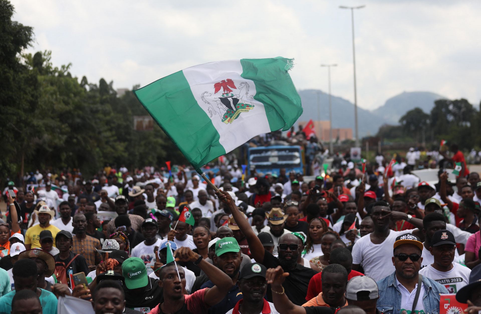 The Nigerian flag is waved above a crowd at a political rally for Labor Party candidate Peter Obi in Abuja, Nigeria, on Sept. 24, 2022. 