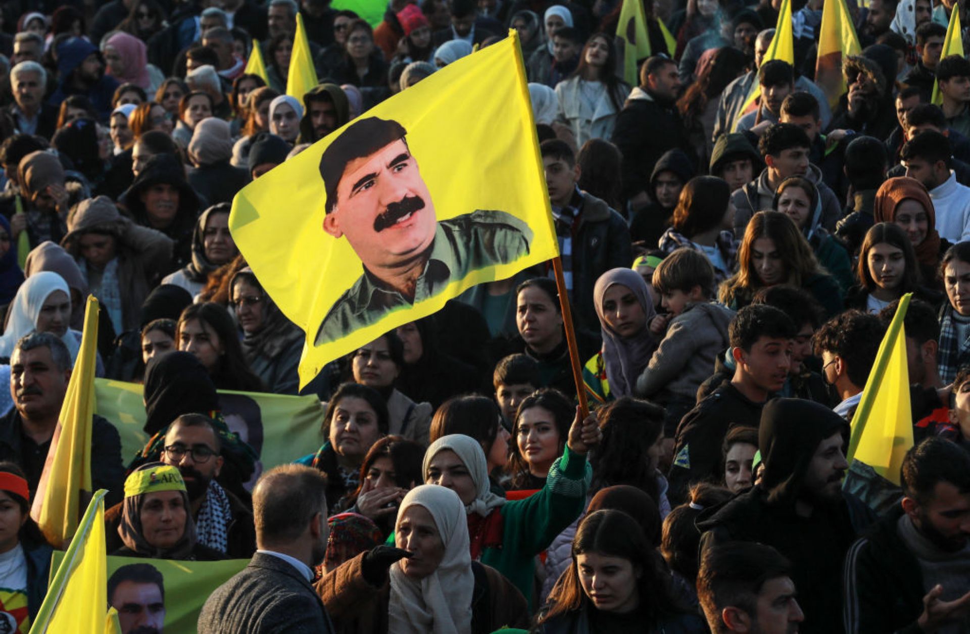 A Syrian Kurdish woman waves a flag bearing a picture of the founder of the Kurdistan Workers' Party (PKK), Abdullah Ocalan, as people gather in the Kurdish-majority city of Qamishli in northeastern Syria to listen to a message from the jailed leader on Feb. 27, 2025. A Syrian Kurdish woman waves a flag bearing a picture of the founder of the Kurdistan Workers' Party (PKK), Abdullah Ocalan, as people gather in the Kurdish-majority city of Qamishli in northeastern Syria to listen to a message from the jailed leader on Feb. 27, 2025.