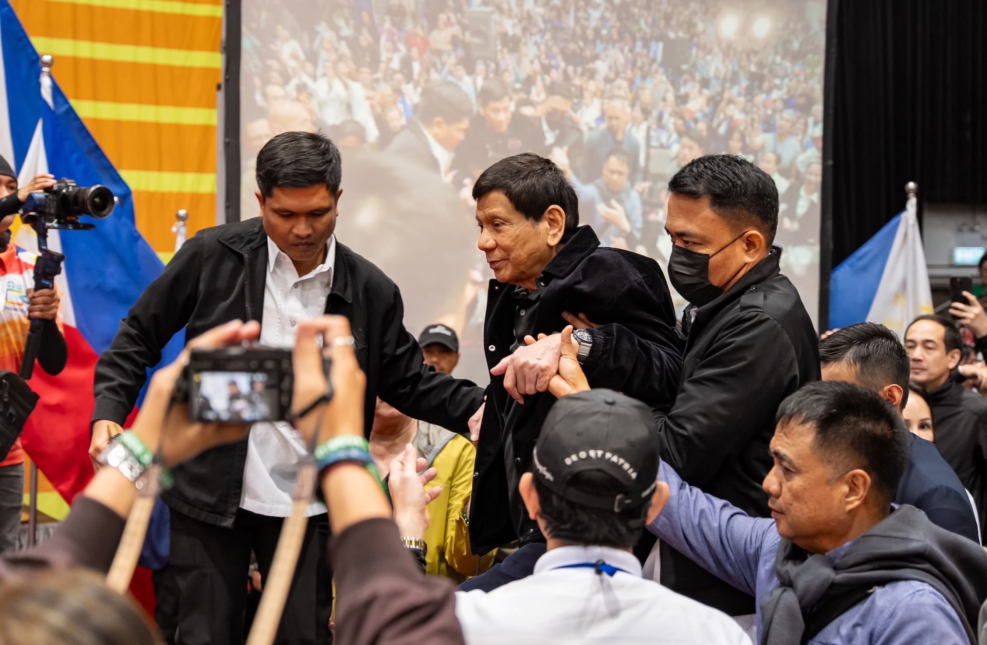 Former Philippine President Rodrigo Duterte is escorted by security personnel as he enters a campaign rally at Southorn Stadium in Hong Kong, China, on March 9, 2025. 