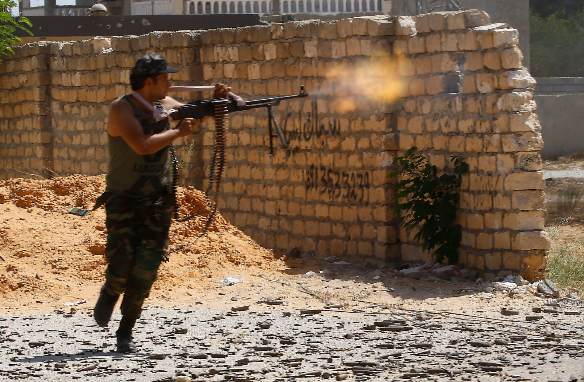 A fighter loyal to Libya's internationally recognized government in Tripoli fires on forces allied with Khalifa Hifter's Libyan National Army during clashes in Ain Zara on Sept. 7, 2019.