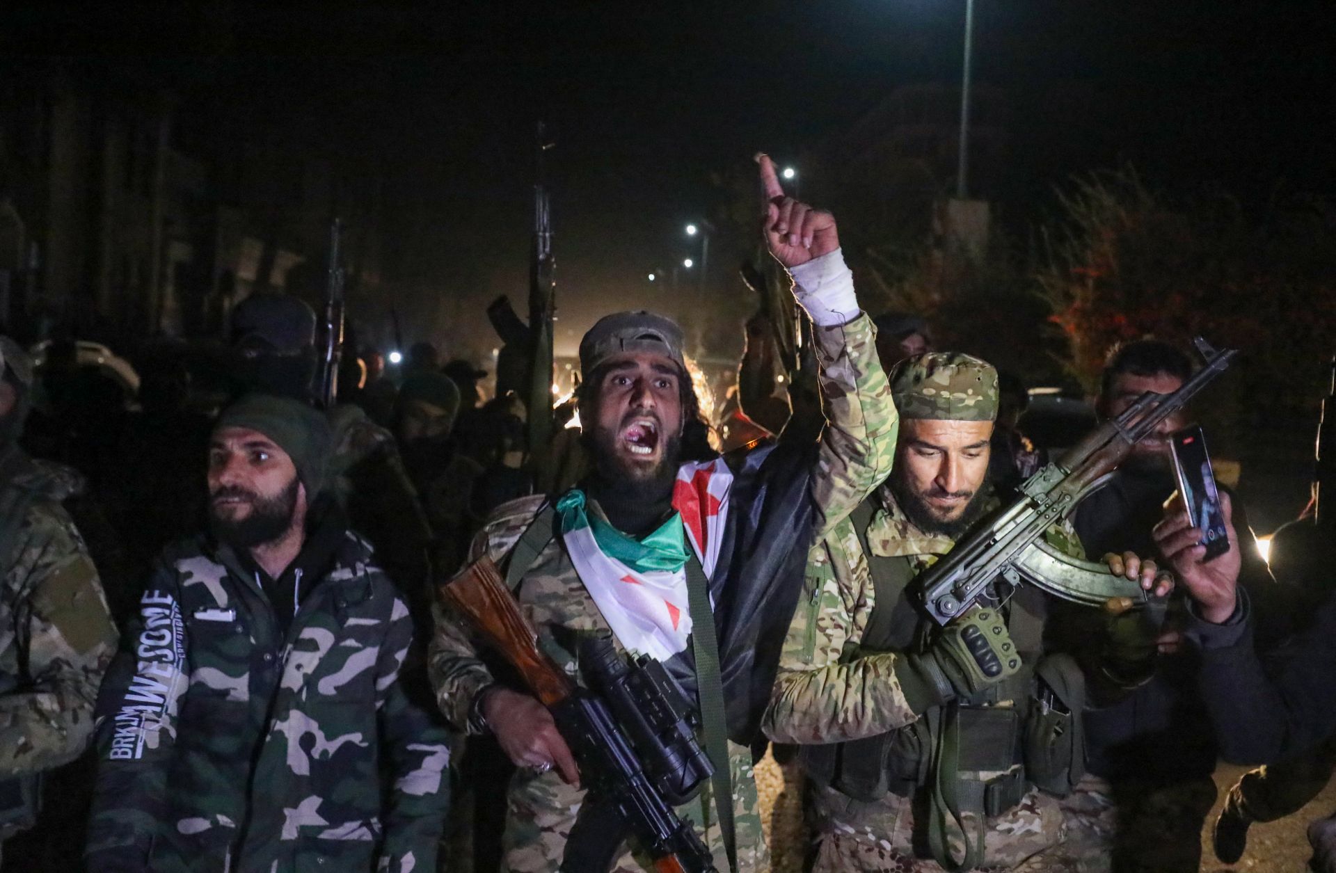 Rebel fighters celebrate in the streets of Homs, Syria, in the early hours of Dec. 8, 2024, after seizing control of the city.