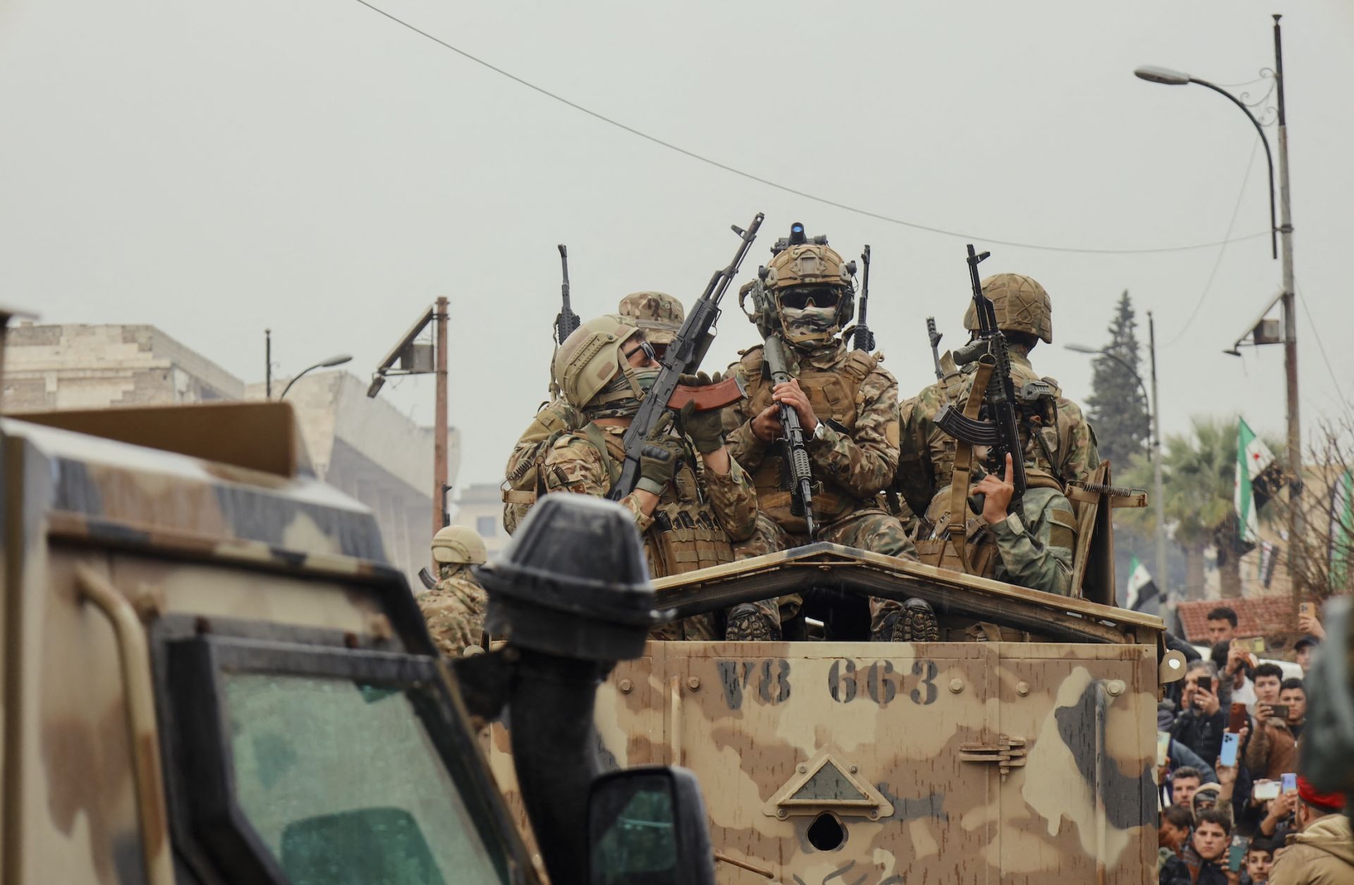 Soldiers ride atop an armored vehicle during a military parade in Idlib, Syria, on Dec. 8, 2025. 