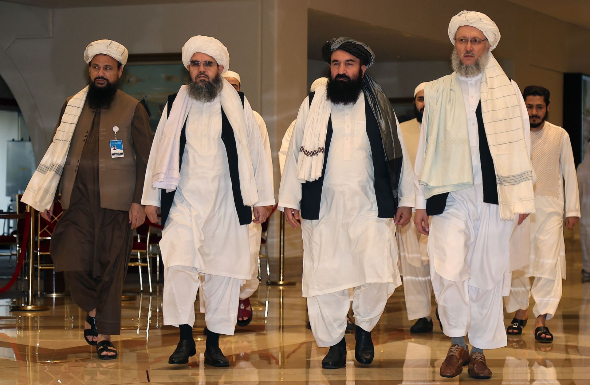 A delegation of Afghan Taliban officials walks down a hotel lobby in Doha, Qatar, in August 2021. 