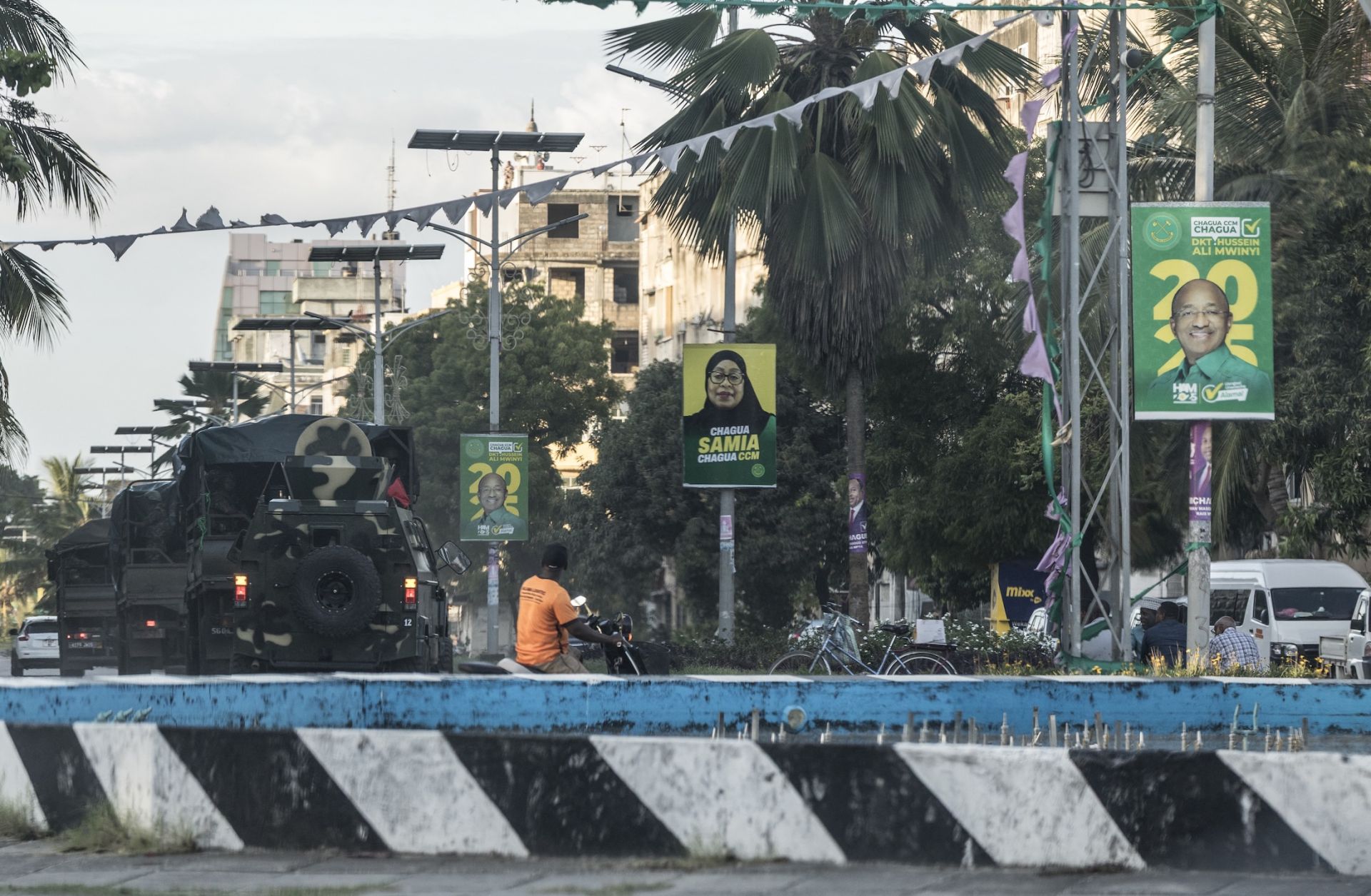 A column of Tanzanian soldiers drives past electoral posters of incumbent Tanzanian President Samia Suluhu Hassan and Zanzibar President Hussein Ali Mwinyi in Stone Town on Oct. 30, 2025. 