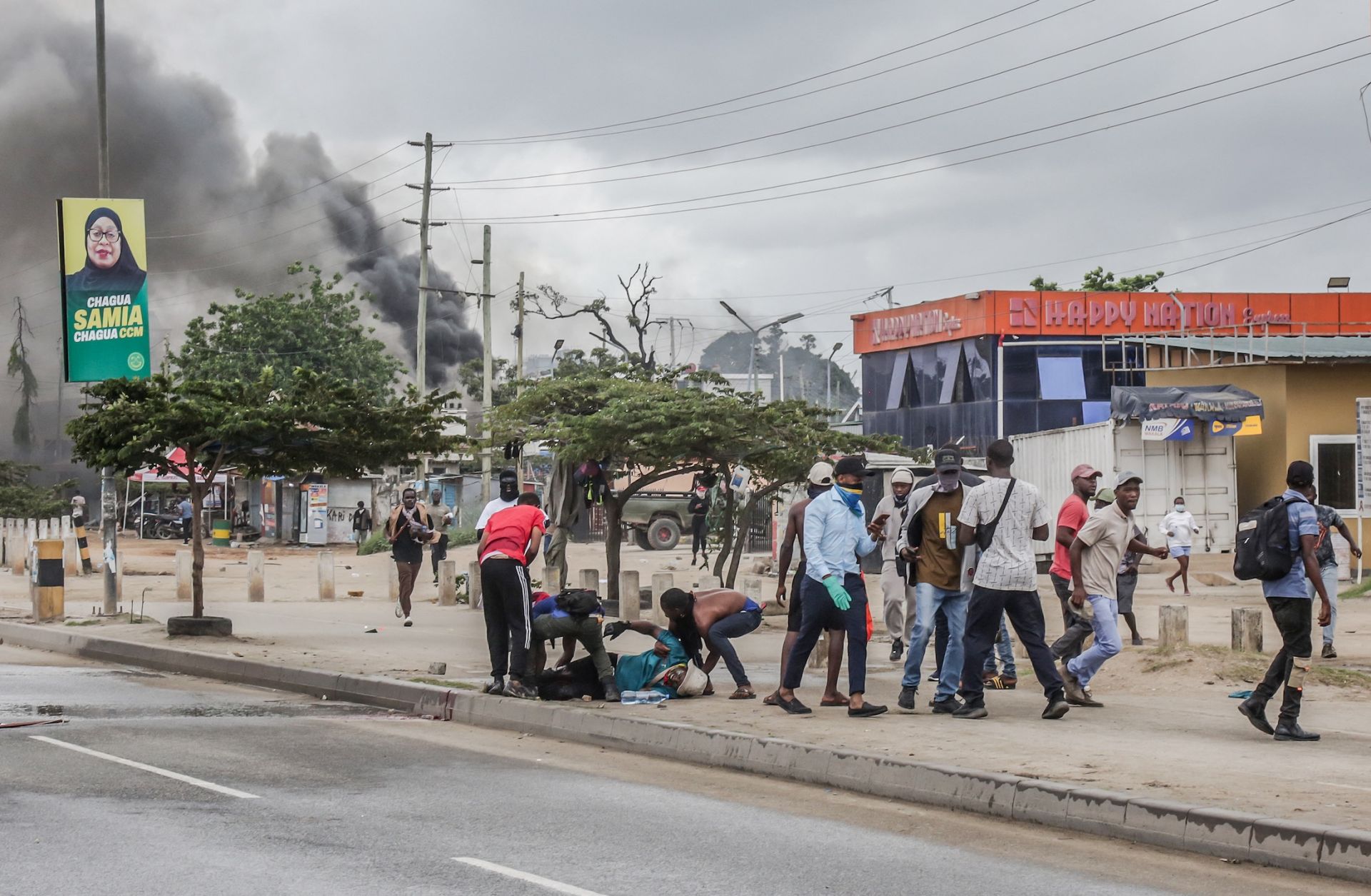 Protesters help an injured demonstrator near burning barricades amid clashes in Dar es Salaam, Tanzania, on Oct. 29, 2025. 