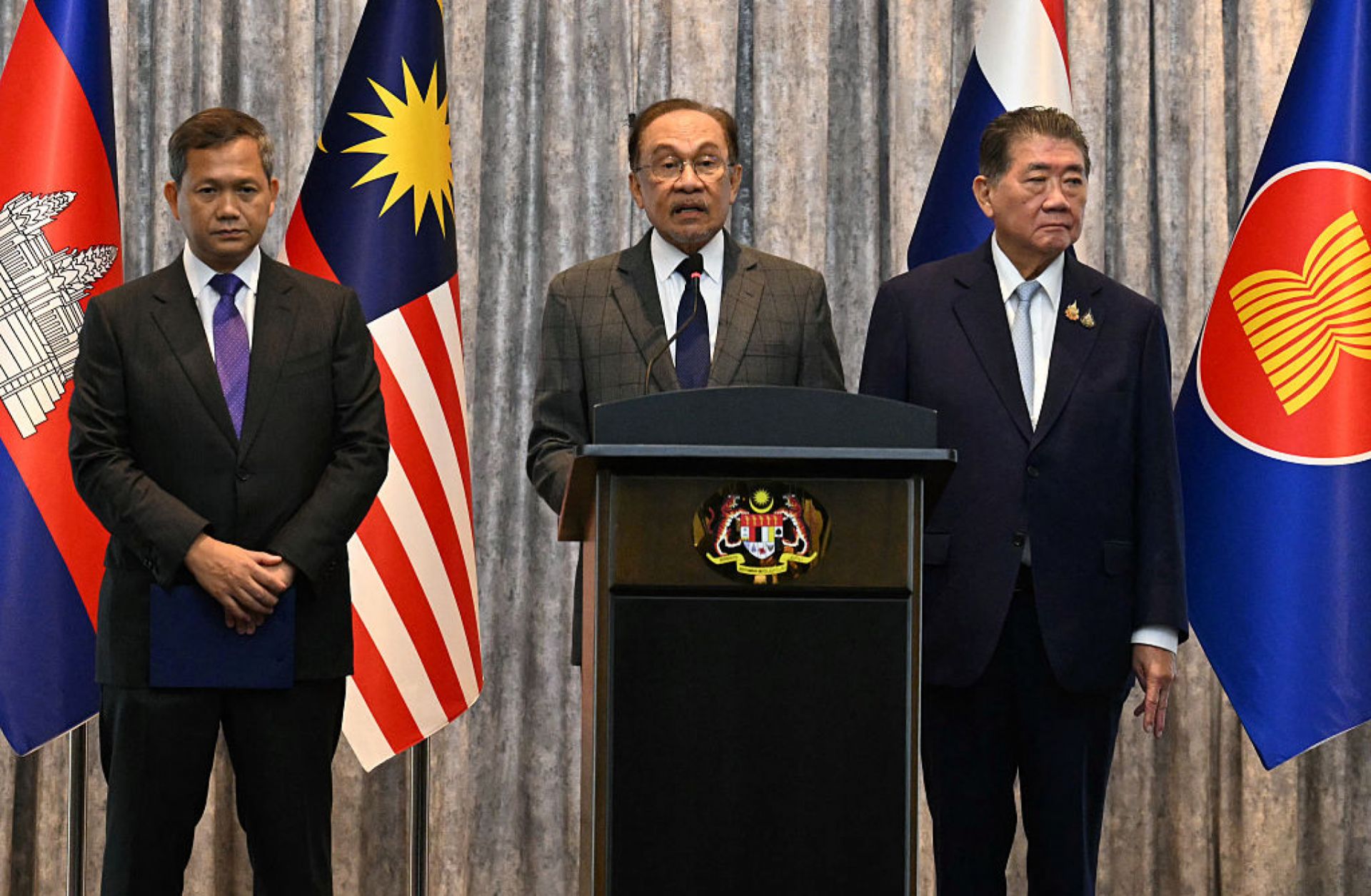 Malaysian Prime Minister Anwar Ibrahim (center) speaks during a press conference next to Cambodian Prime Minister Hun Manet (left) and Thailand's acting prime minister Phumtham Wechayachai (right) in Putrajaya, Malaysia, on July 28, 2025. 