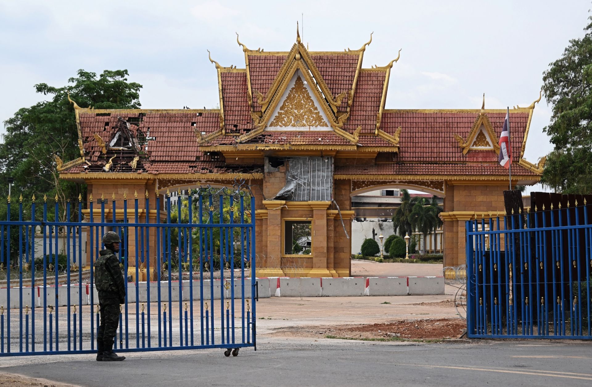 A Thai soldier stands guard at a damaged border crossing point between Surin province's Chong Chom and O'Smach town on the Thai-Cambodian border, on March 12, 2026.