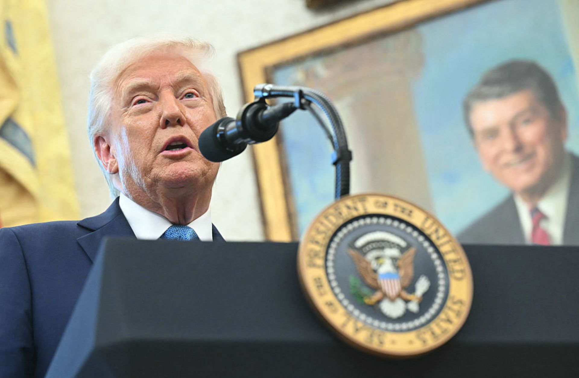 A portrait of former U.S. President Ronald Reagan is seen in the background as U.S. President Donald Trump speaks to reporters in the Oval Office of the White House in Washington, D.C., on April 22, 2025.