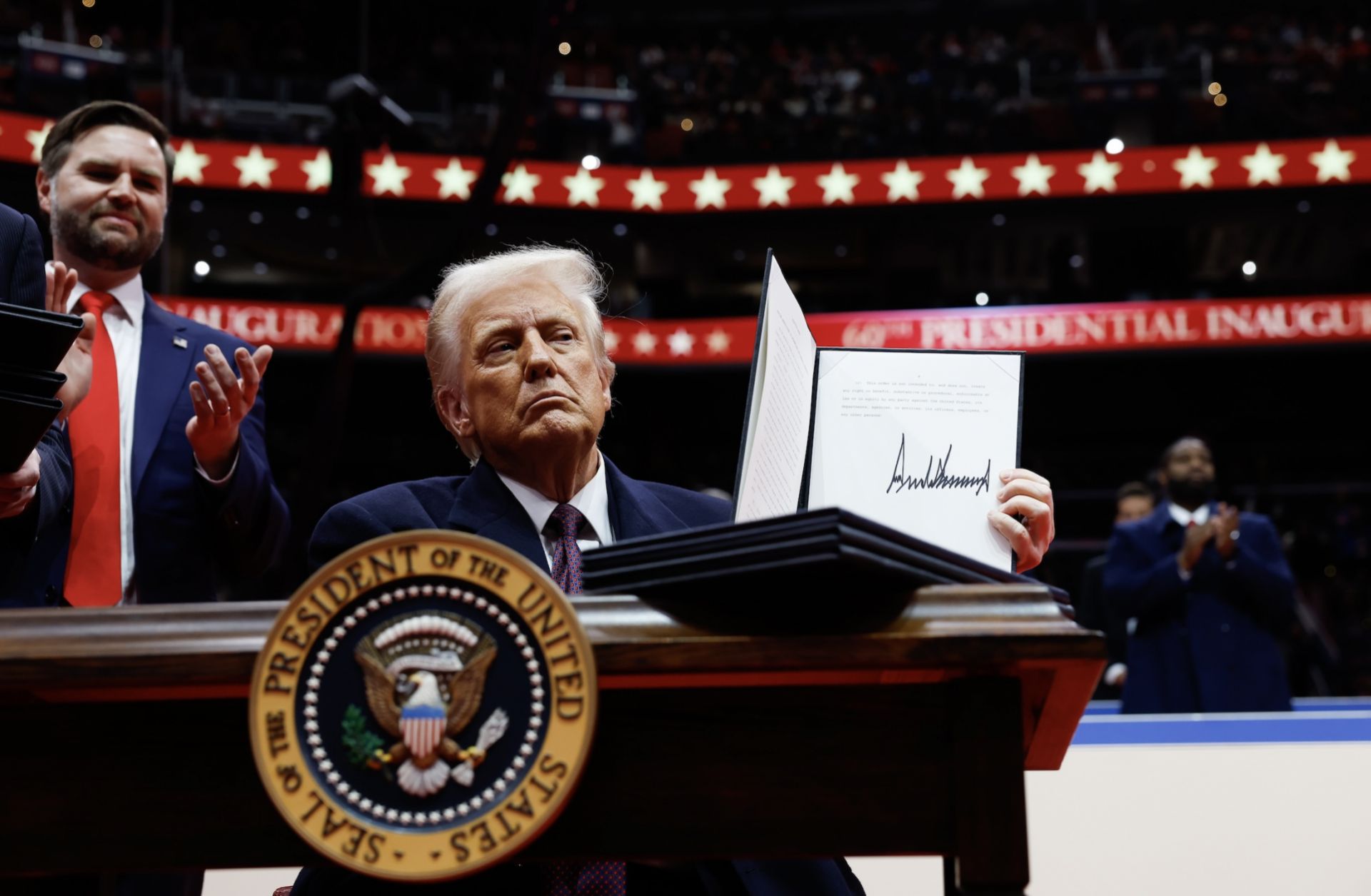 U.S. President Donald Trump holds up an executive order after signing it during an indoor inauguration parade at the Capital One Arena in Washington, D.C, on Jan. 20, 2025.