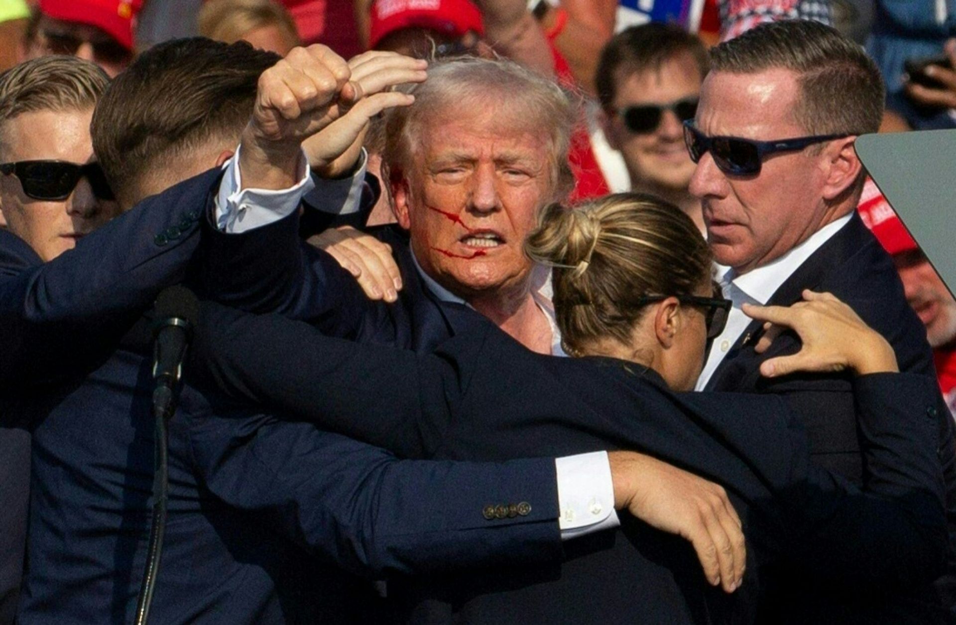 Republican presidential candidate Donald Trump with blood on his face surrounded by secret service agents as he is taken off the stage at a July 13 campaign event in Butler, Pennsylvania.