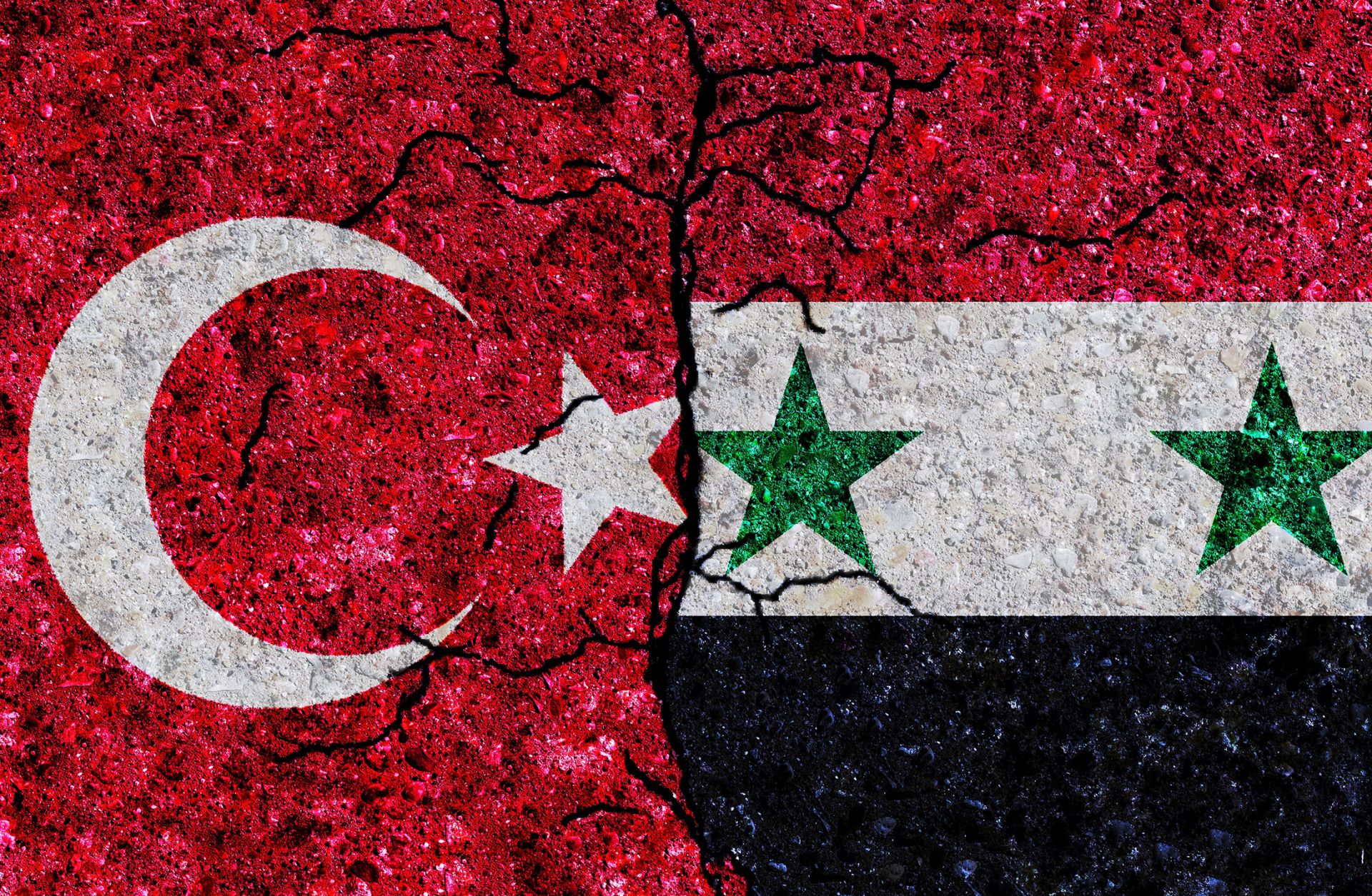 The Turkish and Syrian flags are split by a crack.