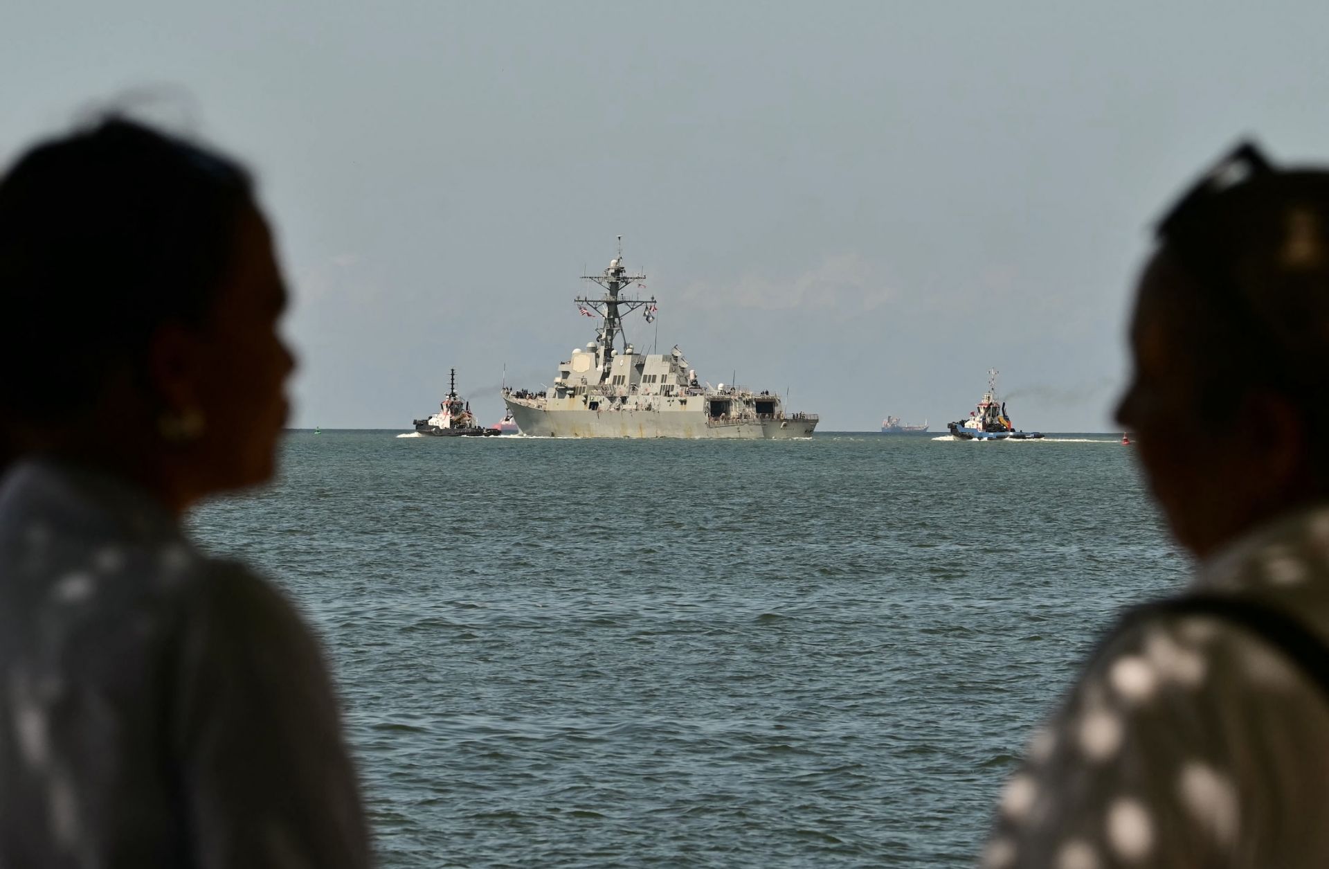 People watch the USS Gravely, a Navy warship, departing the Port of Spain on Oct. 30, 2025. The U.S. warship arrived in Trinidad and Tobago on Oct. 26, 2025, for joint exercises near the coast of Venezuela, as Washington ratcheted up pressure on drug traffickers and Venezuelan leader Nicolas Maduro.
