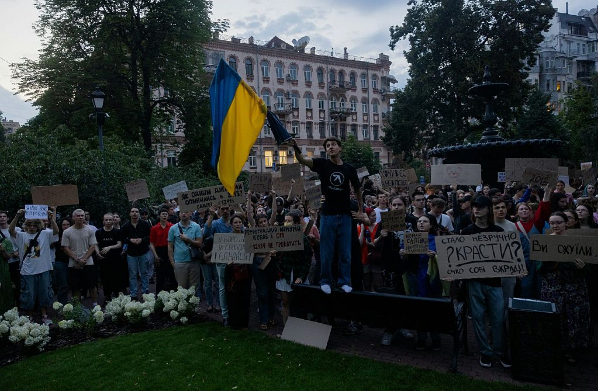 A protester holds a Ukrainian flag in downtown Kyiv on July 22, 2025, during a demonstration calling for President Volodymyr Zelensky to veto a law that reduces the powers of Ukraine's anti-corruption agencies.