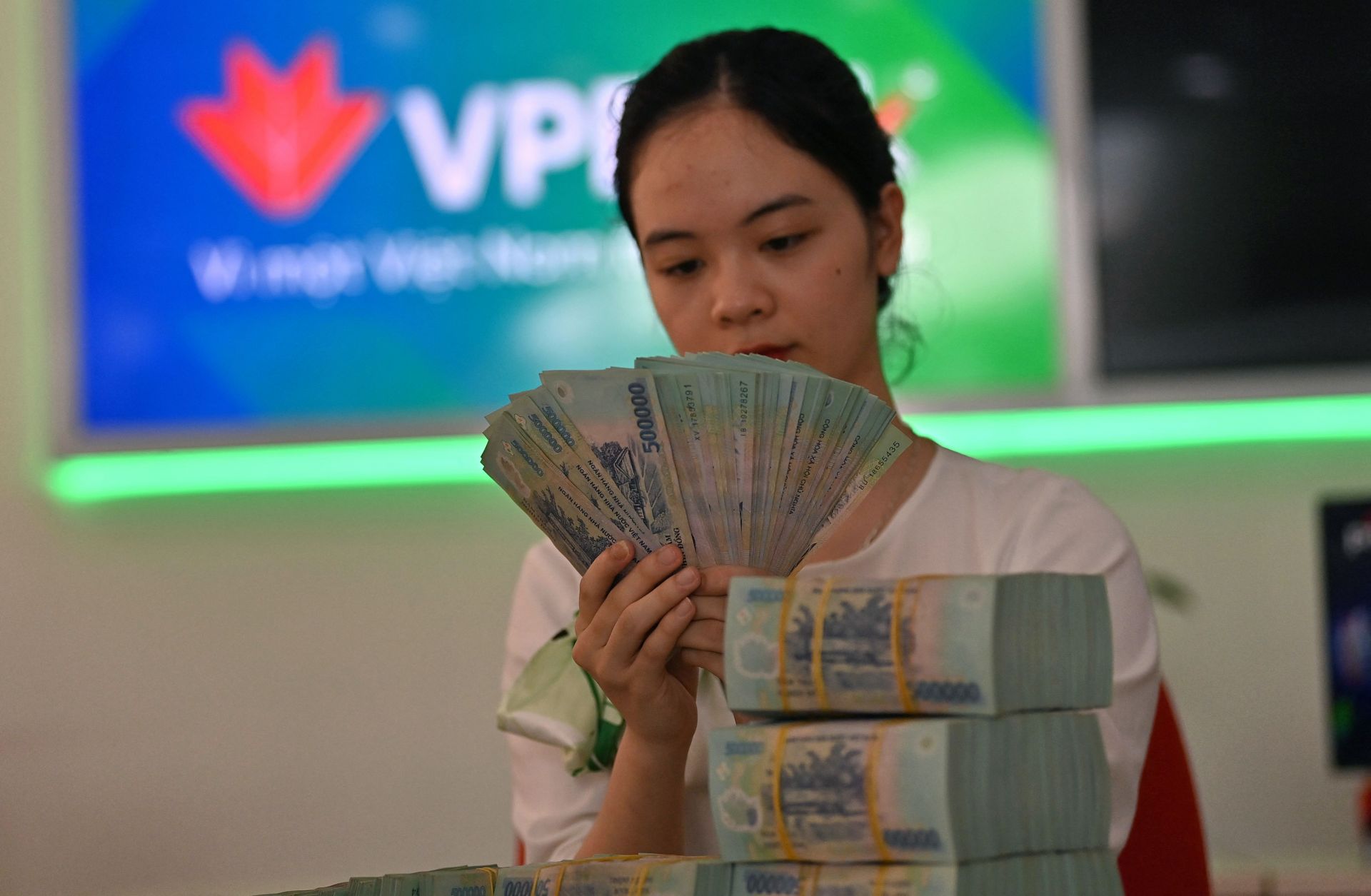 A bank employee checks currency notes at a branch of VPBank in Hanoi, Vietnam, on June 29, 2023, after authorities announced the country's economic growth had slowed in the first half of the year. 