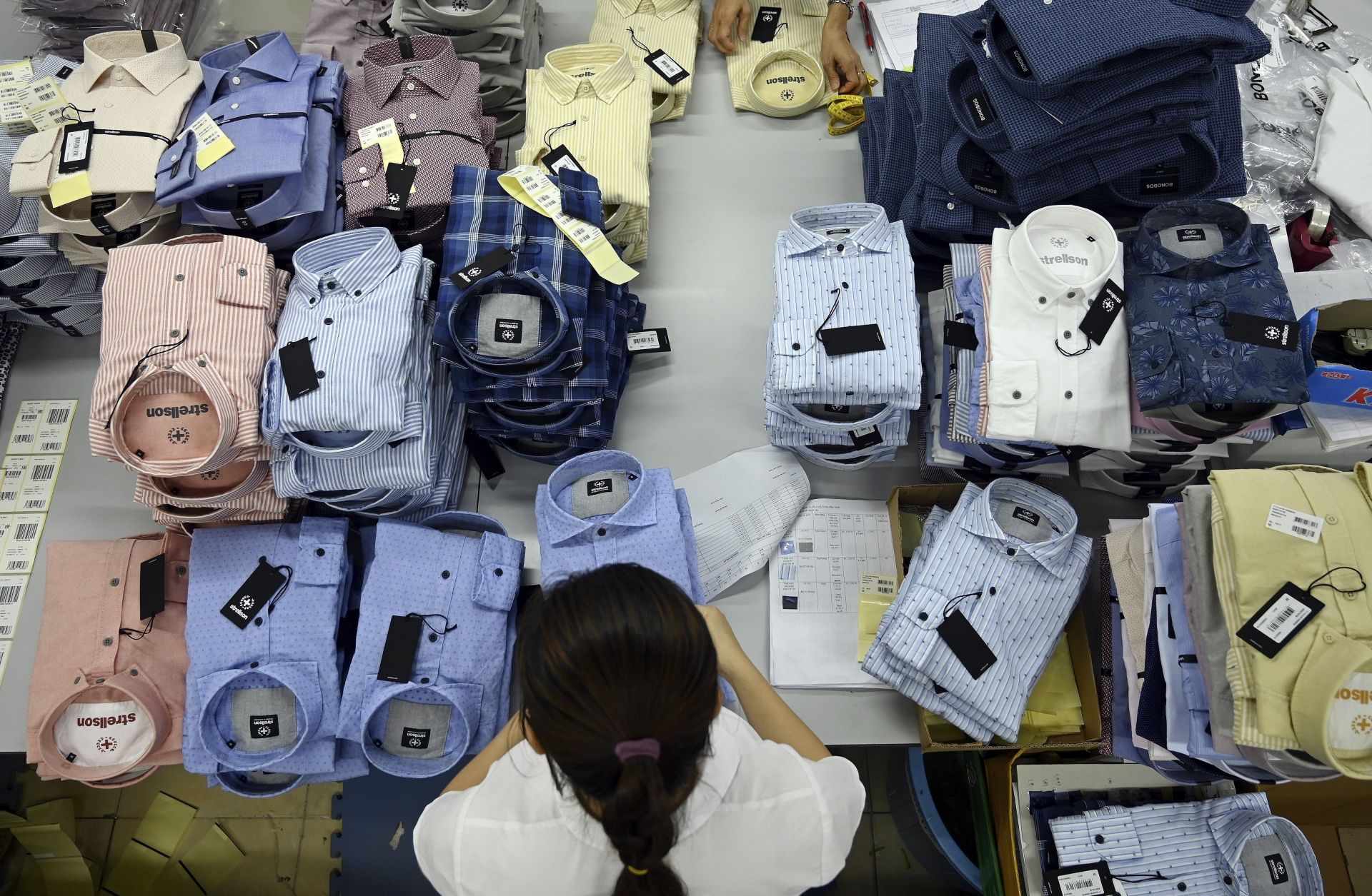 Vietnam has been a key low-end manufacturing hub for years, but the U.S.-China trade war has prompted some higher-end manufacturing to shift from China to Vietnam and elsewhere. A garment worker prepares shirts for shipment in a factory in Hanoi, Vietnam, on May 24, 2019.