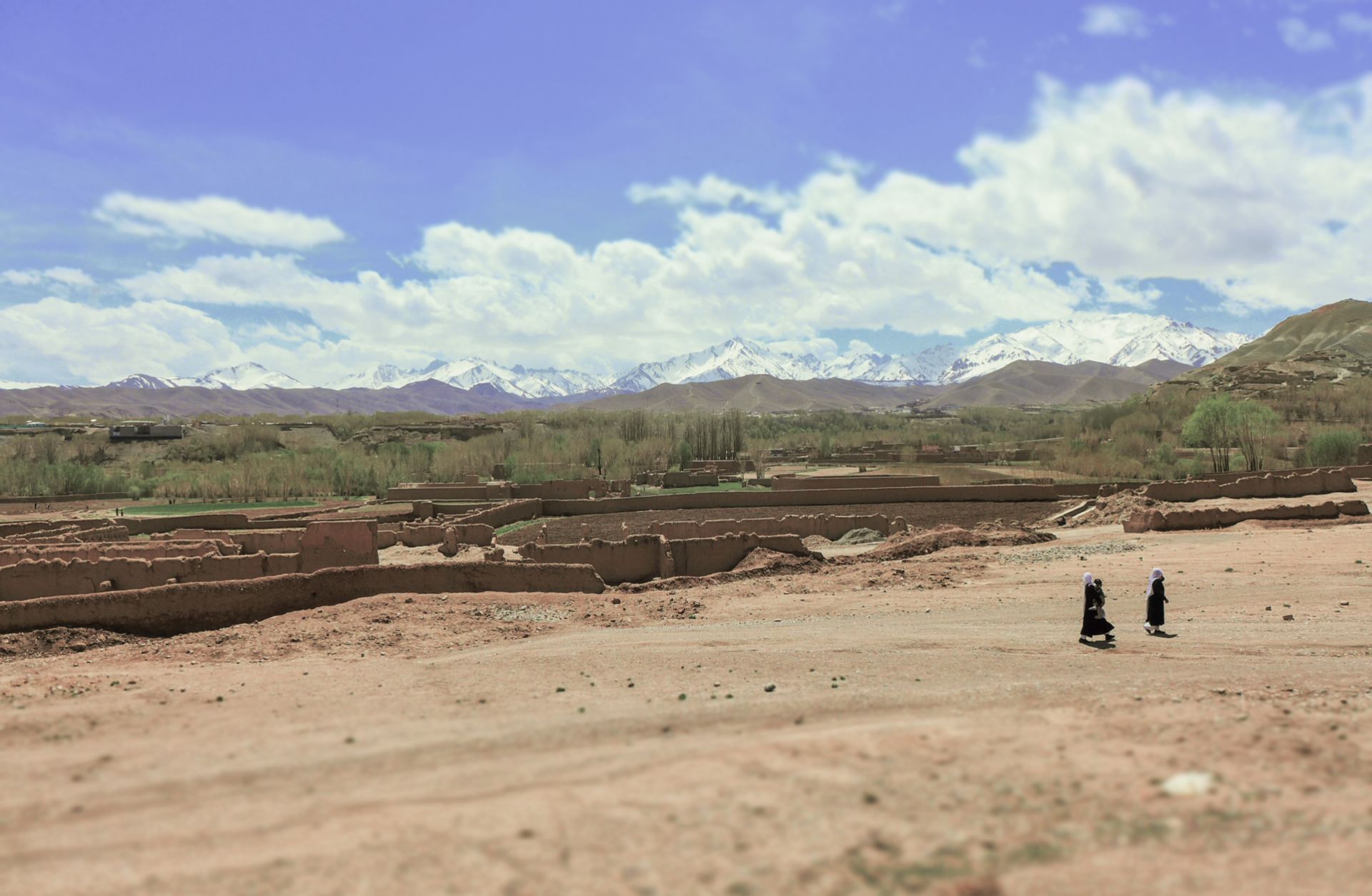 Villagers walk across a striking Afghan rural landscape. 