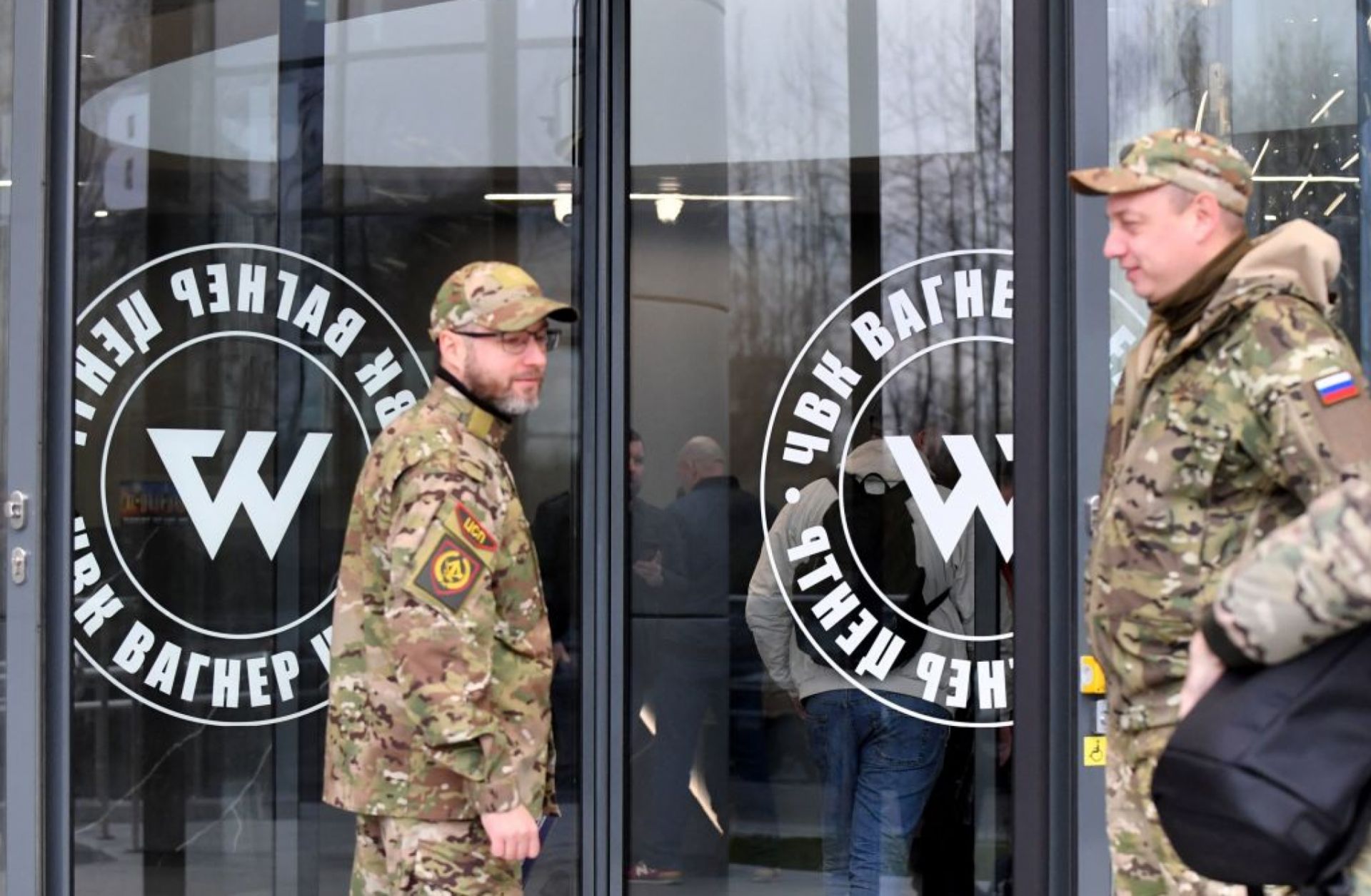 Visitors wearing military camouflage stand at the entrance of the ''PMC Wagner Center,'' which is associated with the founder of the Wagner private military group (PMC), Yevgeny Prigozhin, in Saint Petersburg, Russia, on Nov. 4, 2022.