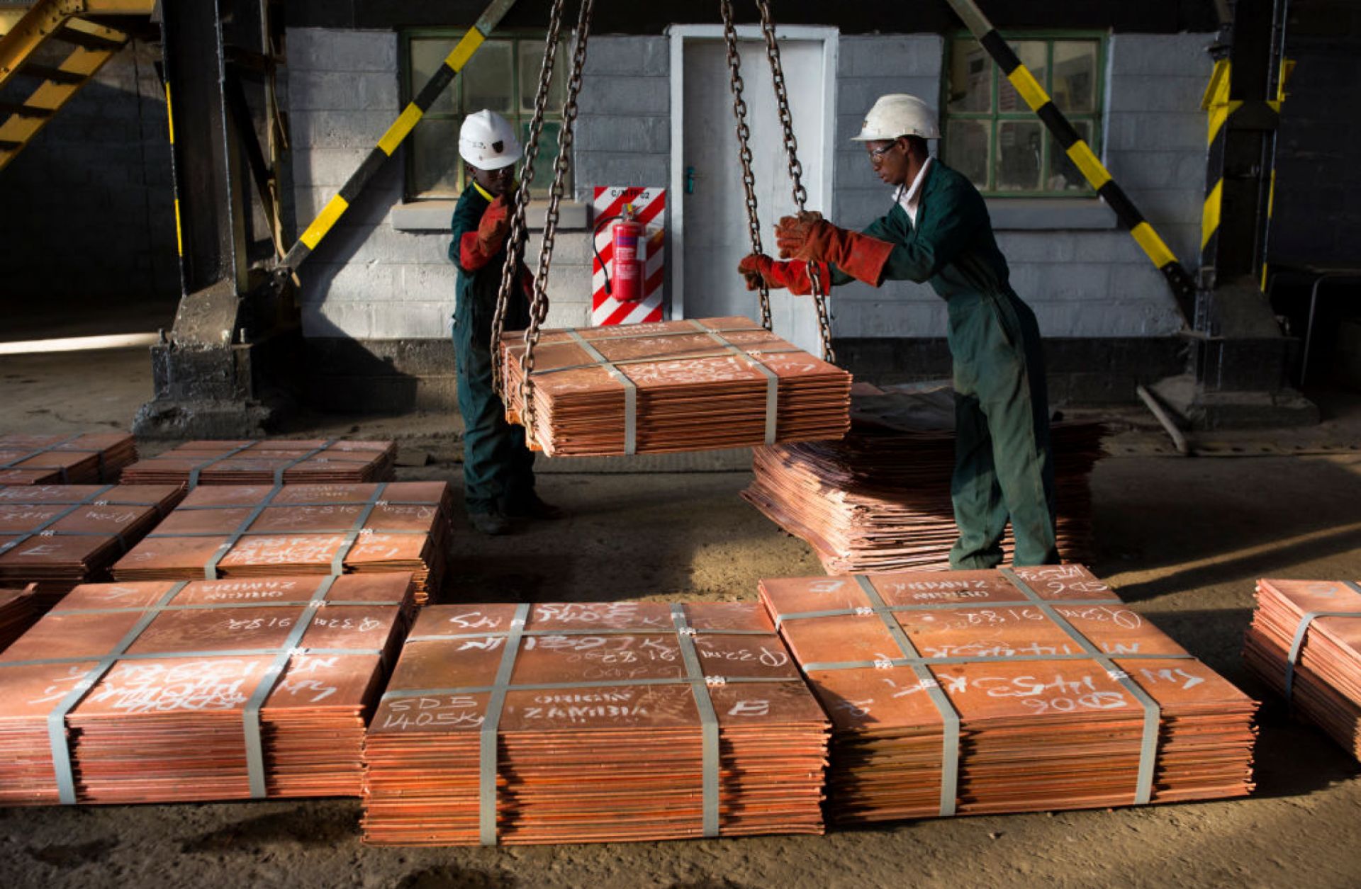 Workers move batches of copper sheets on July 6, 2016, in Mufulira, Zambia.