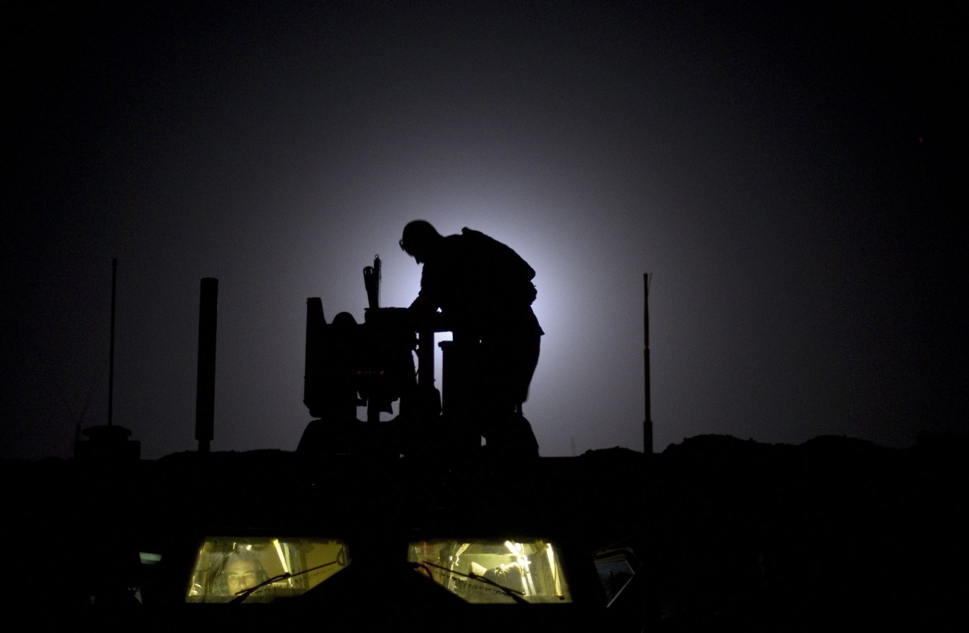 As the 10th anniversary of the Afghanistan War neared in 2011, a U.S. soldier readies his weapon at a forward operating base.
