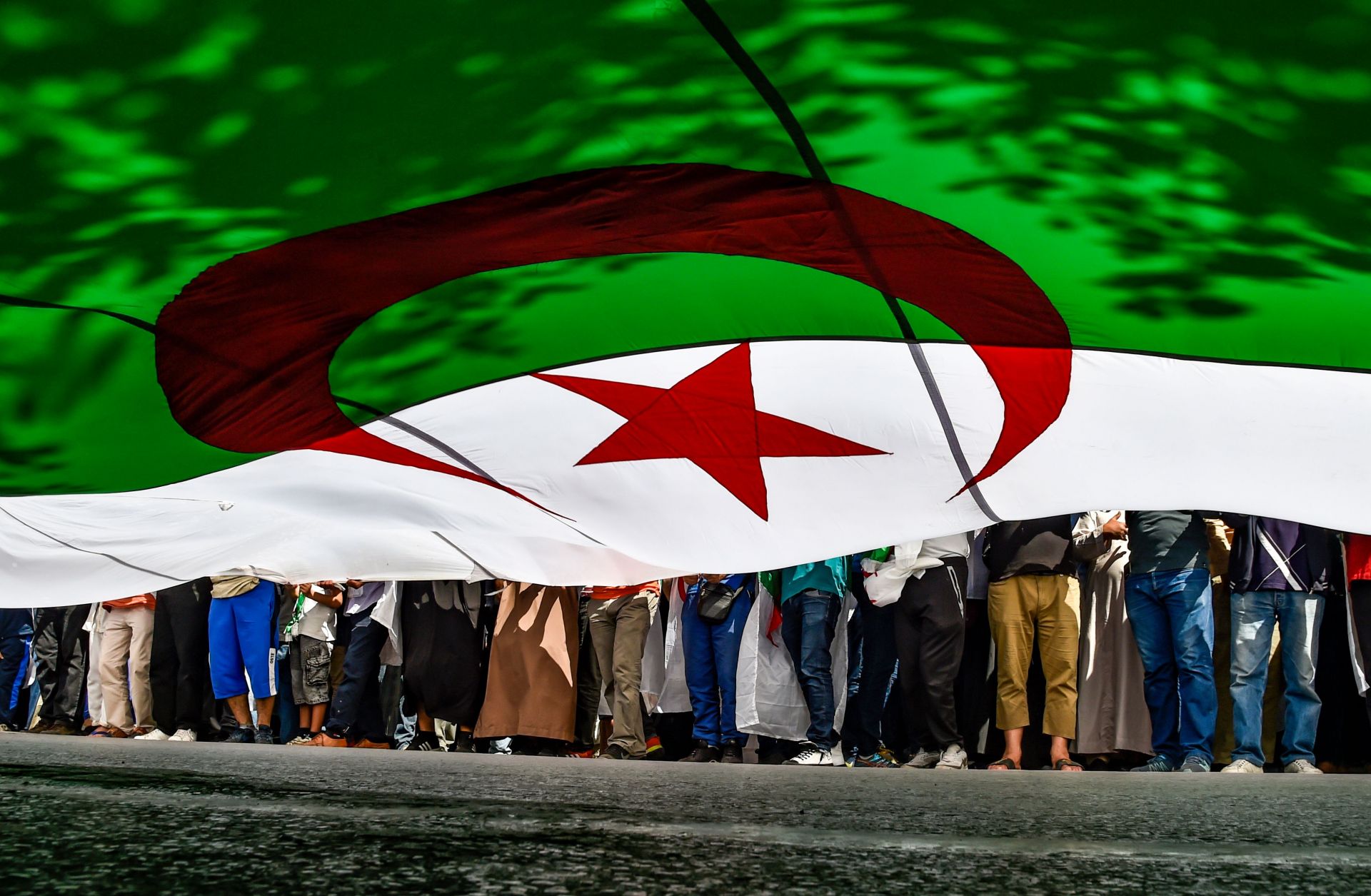 Protesters bearing an Algerian flag march in Algiers on May 31, 2019.