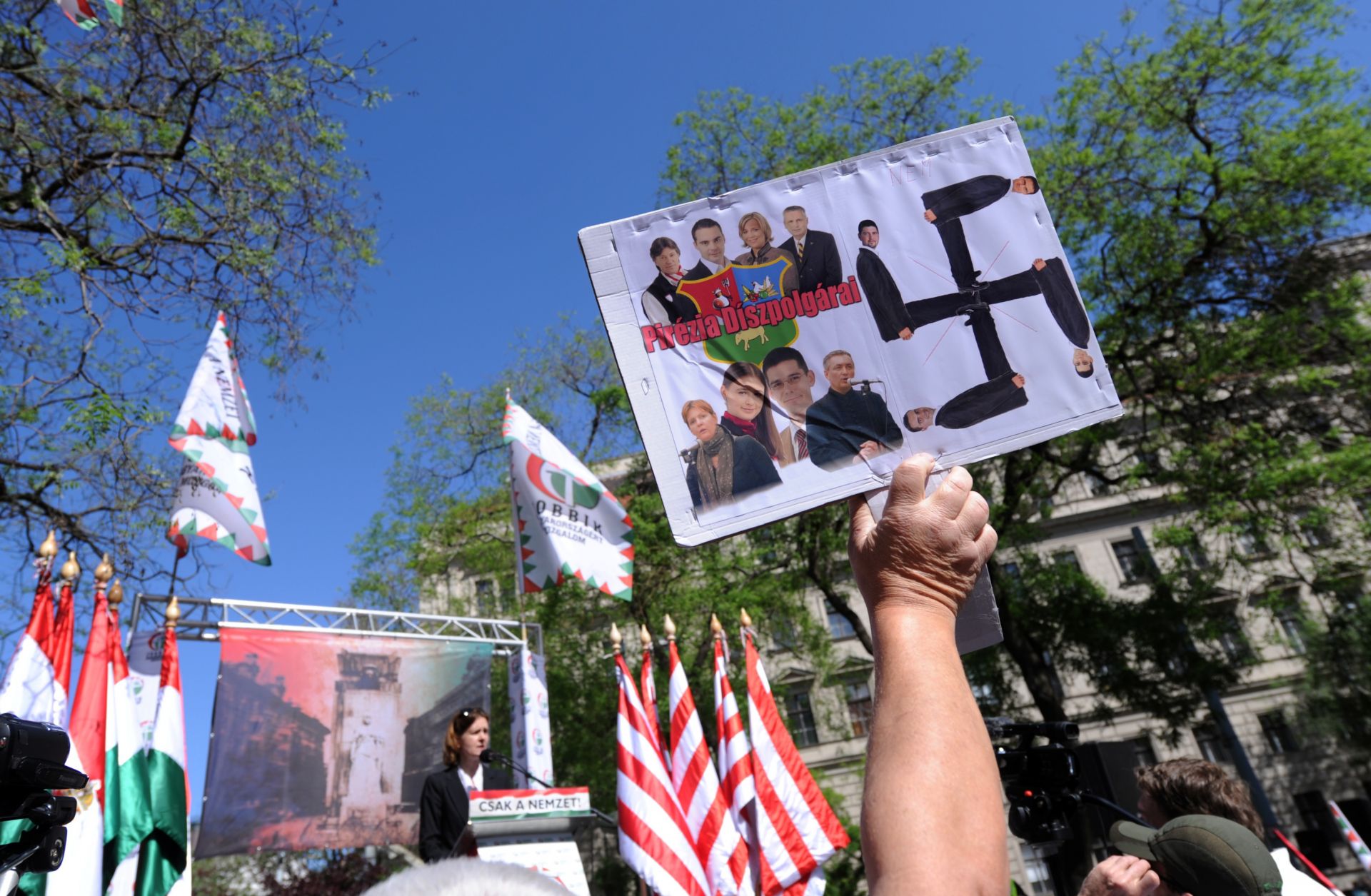 An anti-demonstrator lifts a home-made picture with a Swastika and photos of the party leaders and representatives of the nationalist party of the Hungarian Parliament.