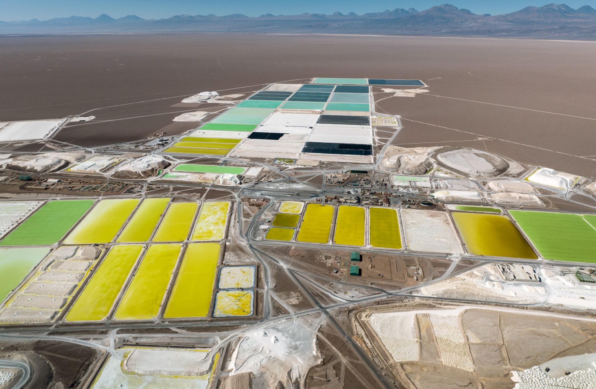 In this aerial view, pools of brine containing lithium carbonate and mounds of salt byproduct stretch through a lithium mine in the Atacama desert on Aug. 24, 2022, in Salar de Atacama, Chile.