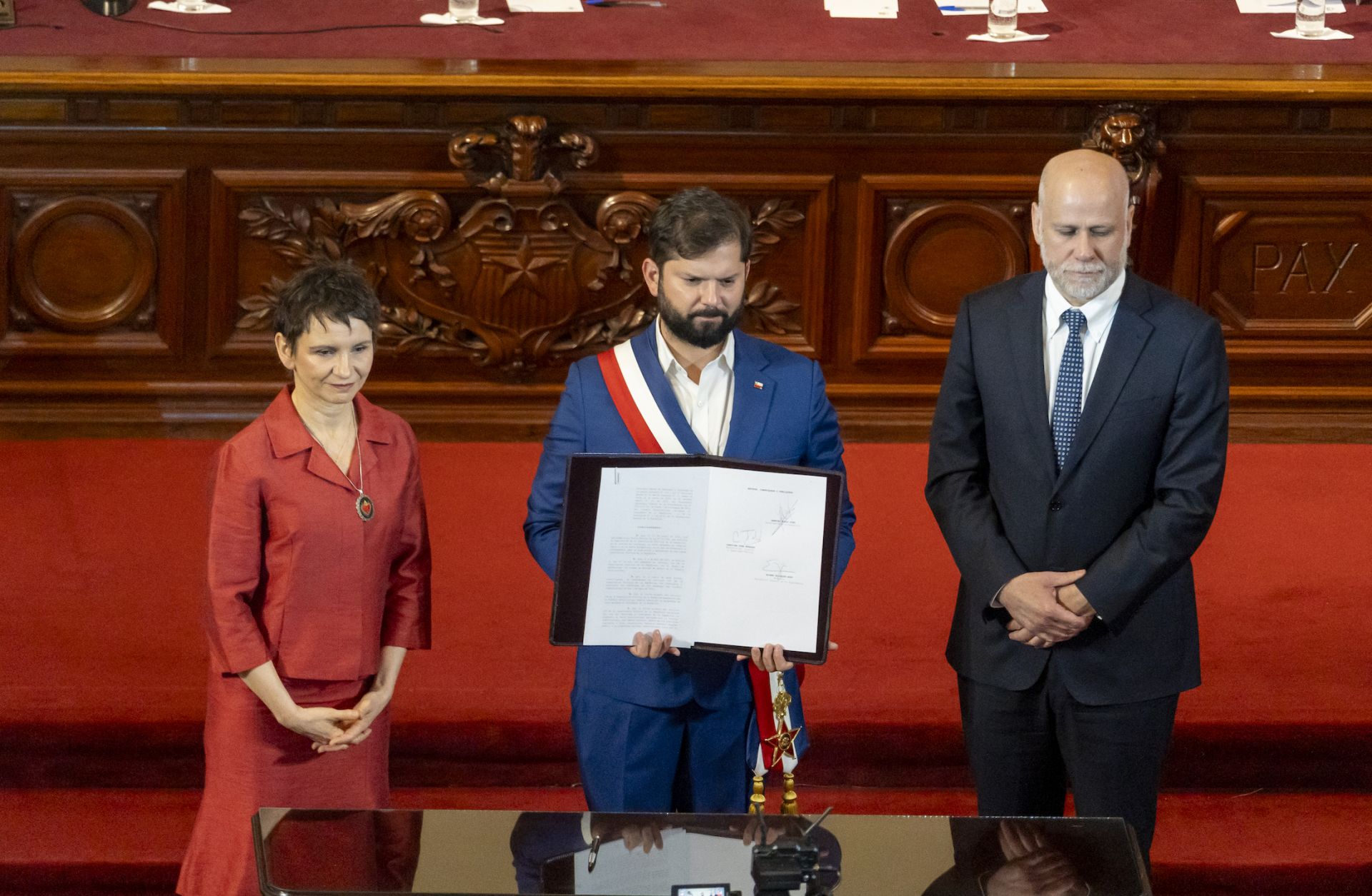 Chilean President Gabriel Boric (center) shows a signed decree that calls for a referendum to approve a new constitution on Nov. 7, 2023, in Santiago, Chile.