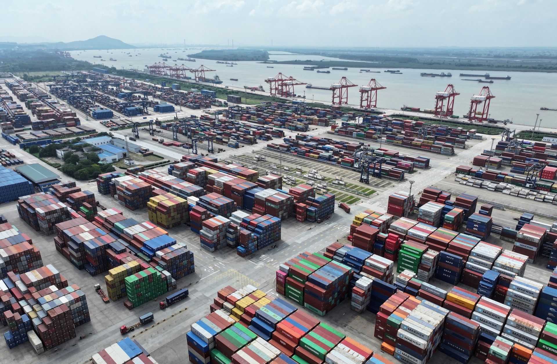 A truck drives between shipping containers at Nanjing port in China's eastern Jiangsu province on Aug. 6, 2023.