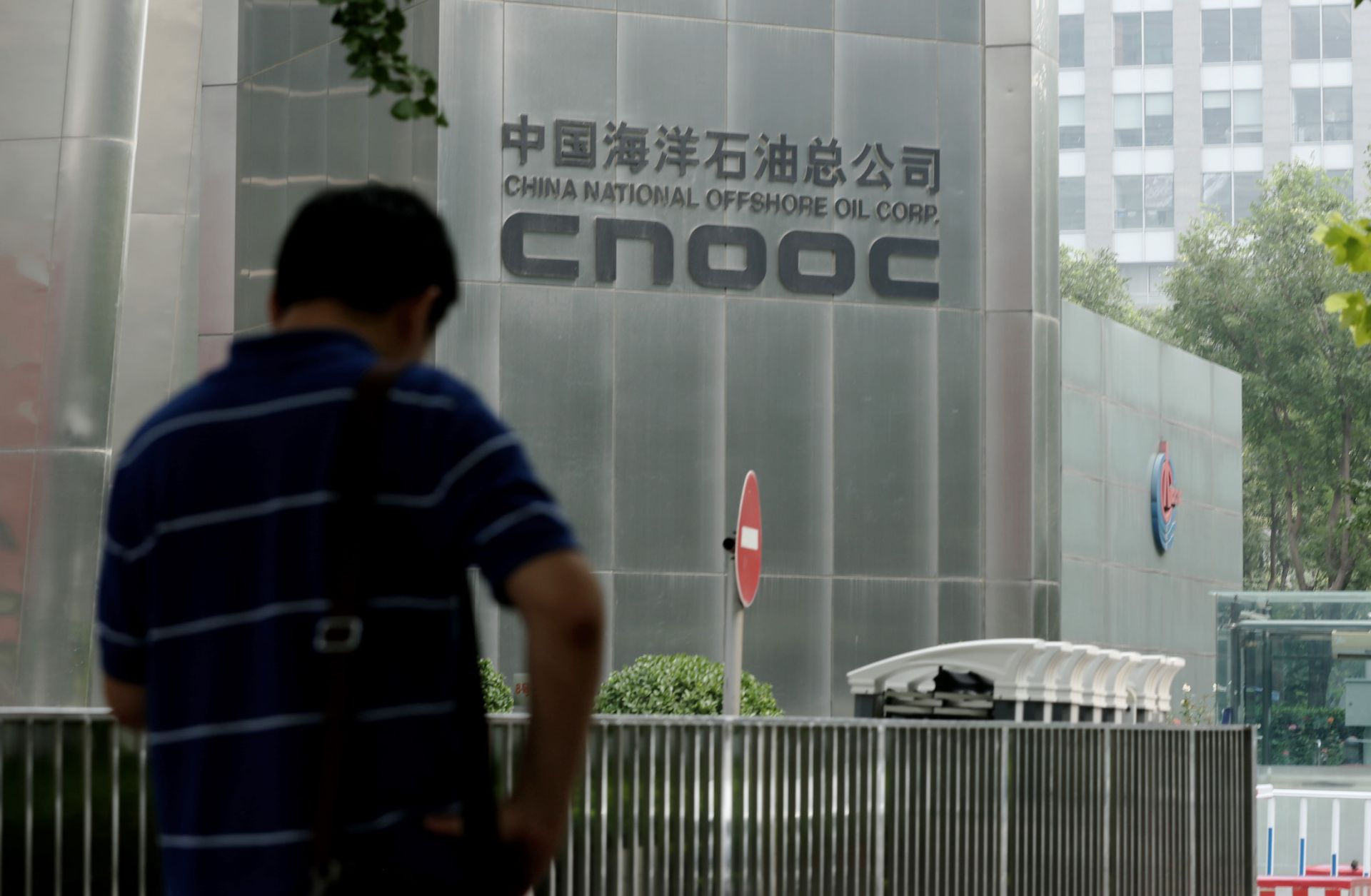 A man stands outside the CNOOC headquarters building in Beijing, China, on July 29, 2016. Targeting China’s third-largest oil company highlights the South China Sea’s importance to U.S. strategy, which is unlikely to change under Biden.