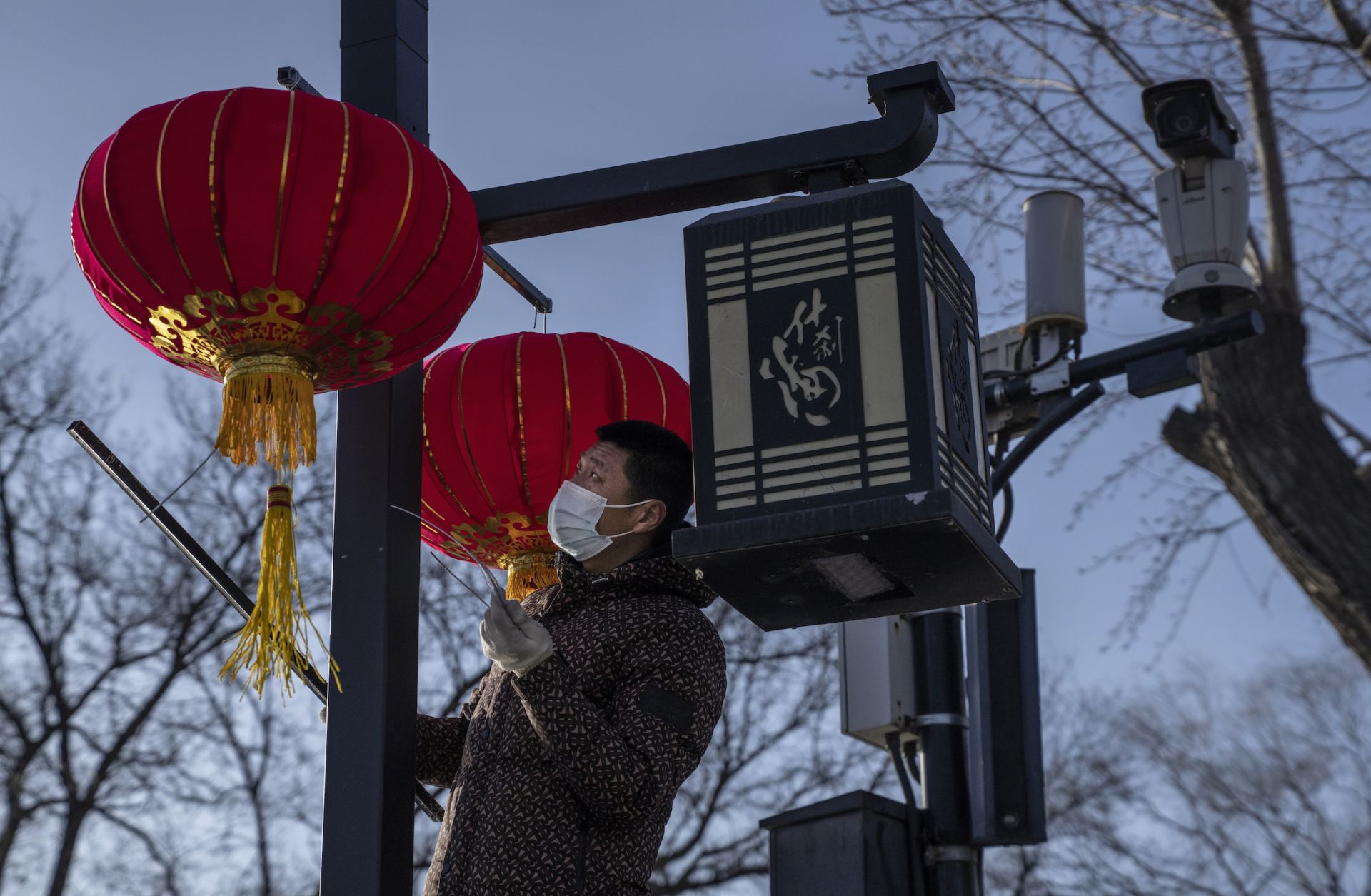 A worker hangs traditional red lanterns for the upcoming Spring Festival on Feb. 3, 2021, in Beijing.