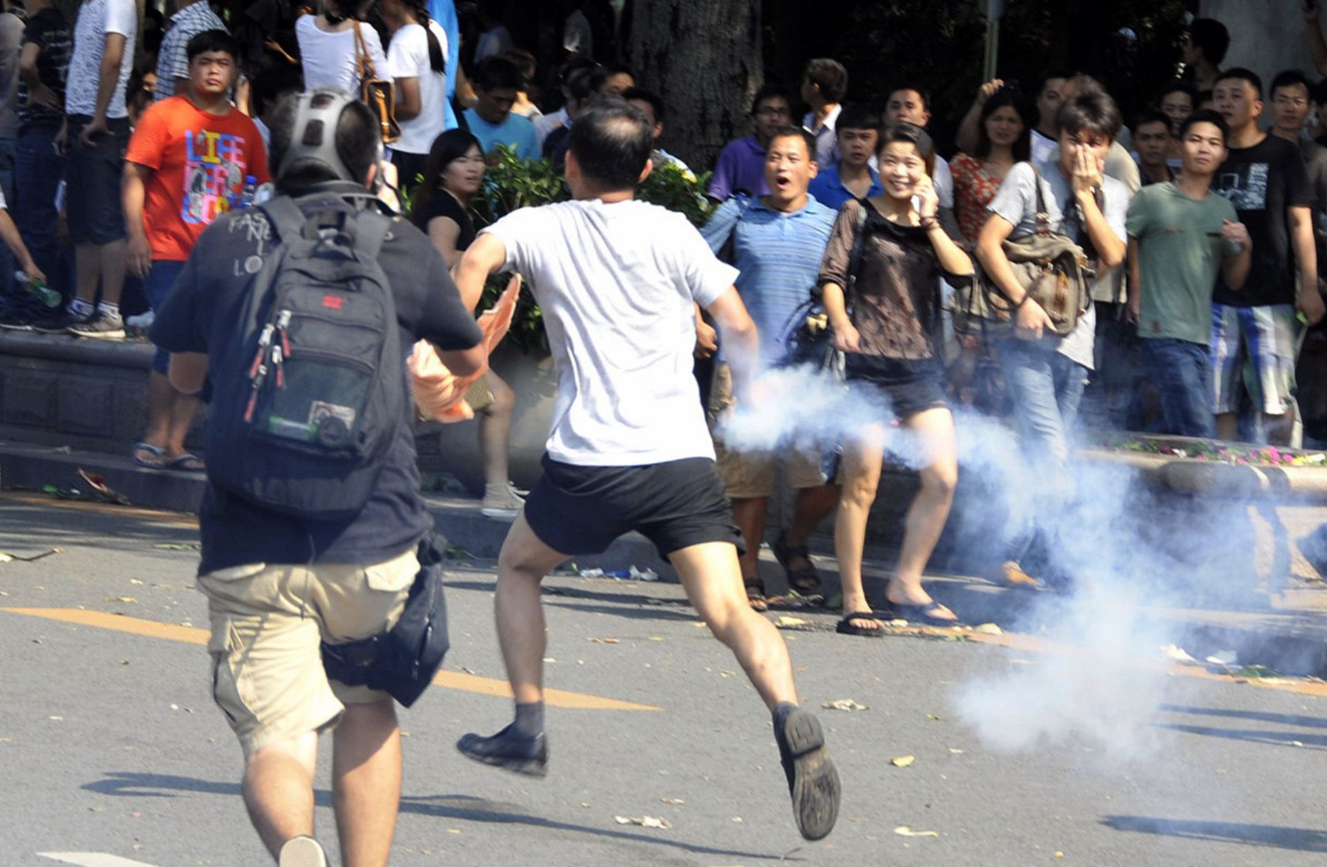 This picture shows a Chinese demonstrator throwing back a tear gas bottle during an anti-Japan protest in September 2012. 