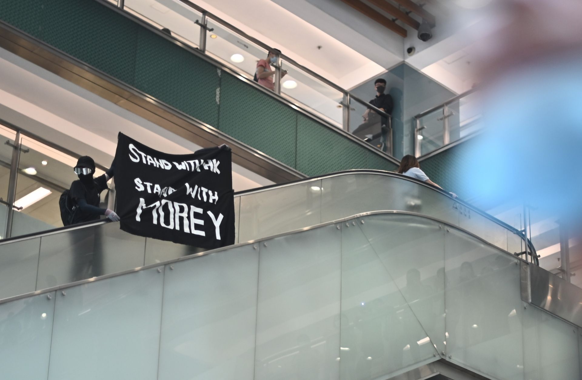 This photo shows a protester in Hong Kong waving a banner of support for NBA team executive Daryl Morey.
