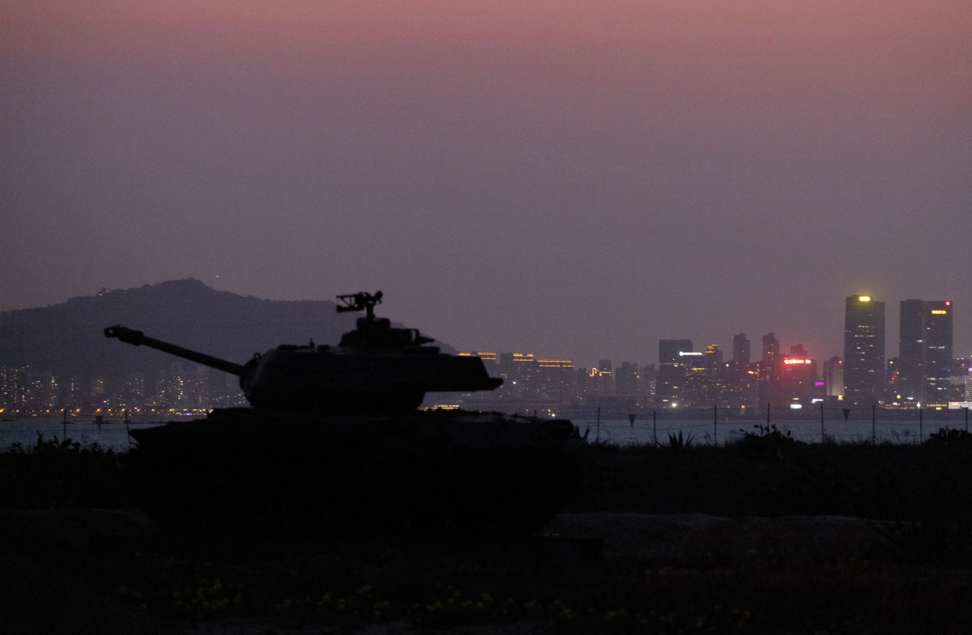 A Taiwanese tank on display for tourists is seen silhouetted against the skyline of the Chinese city Xiamen in Kinmen, Taiwan, an island in the Taiwan Strait that is part of Taiwan's territory.
