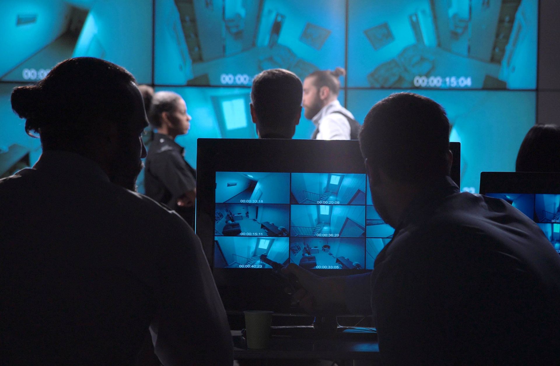 A corporate surveillance team examines security footage of an office entrance. 