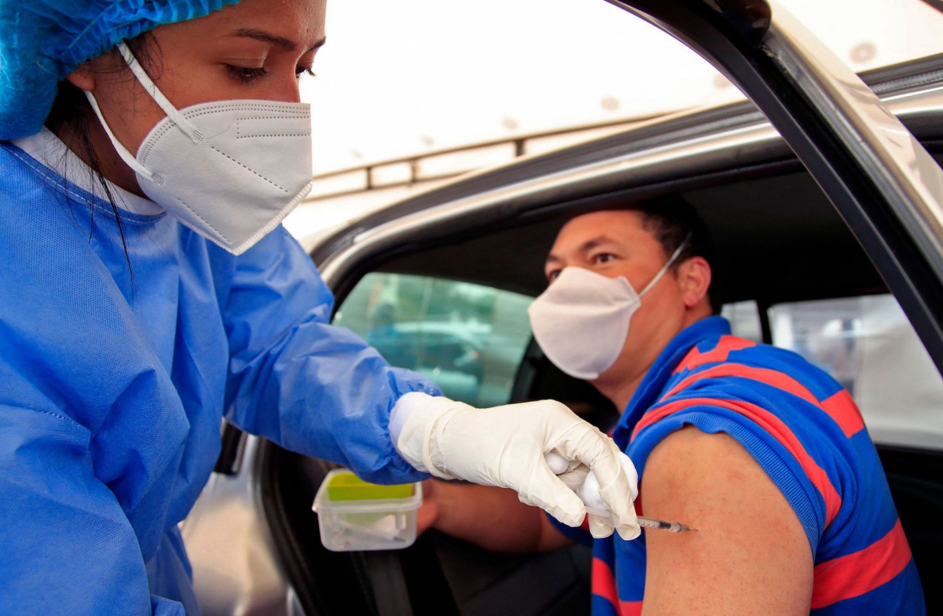 A man receives a dose of a COVID-19 vaccine at a drive-through distribution site in Bogota, Colombia, on April 11, 2021. A man receives a dose of a COVID-19 vaccine at a drive-through distribution site in Bogota, Colombia, on April 11, 2021.