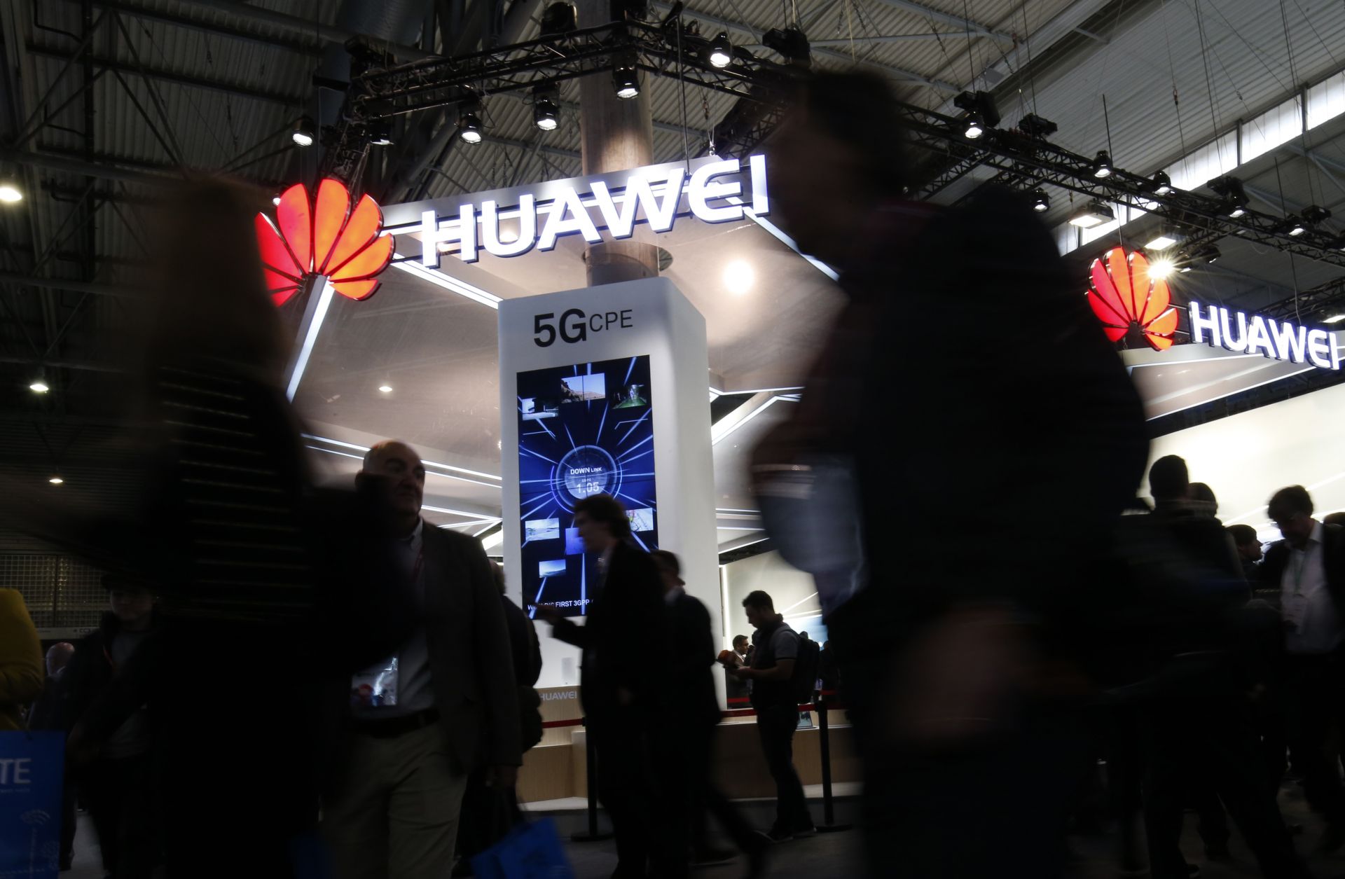 Conference attendees walk past a booth for Chinese telecommunications company at the Mobile World Congress in Barcelona, Spain. Huawei has not drawn the concern in Europe that it has in the United States.