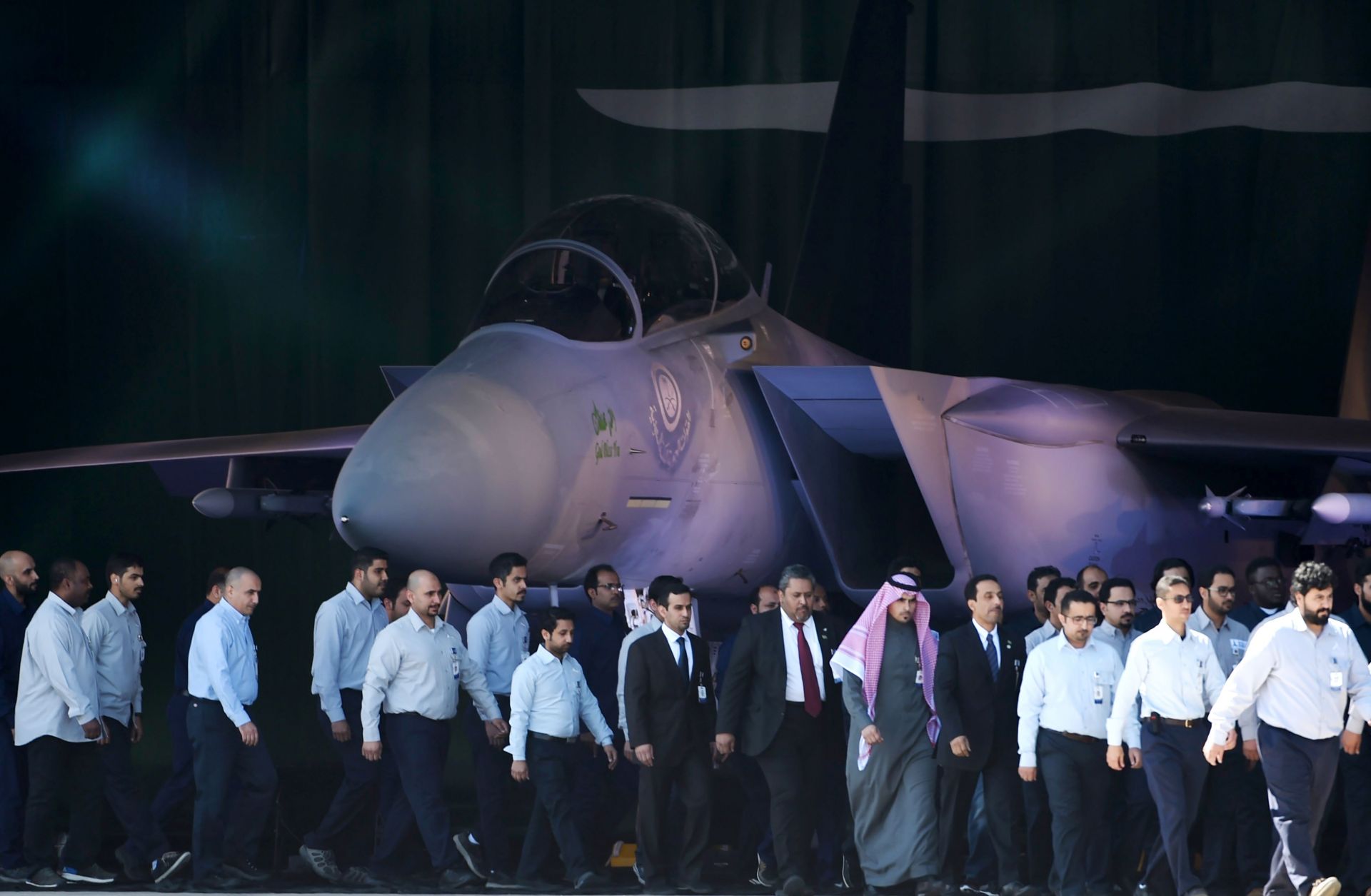 Saudi air force officers and technical staff walk past an advanced F-15SA fighter jet during a ceremony on Jan. 25, 2017 in Riyadh marking the 50th anniversary of the creation of the King Faisal Air Academy.