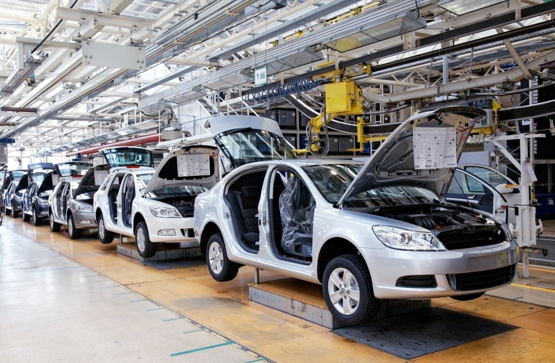 Cars sit on an assembly line.