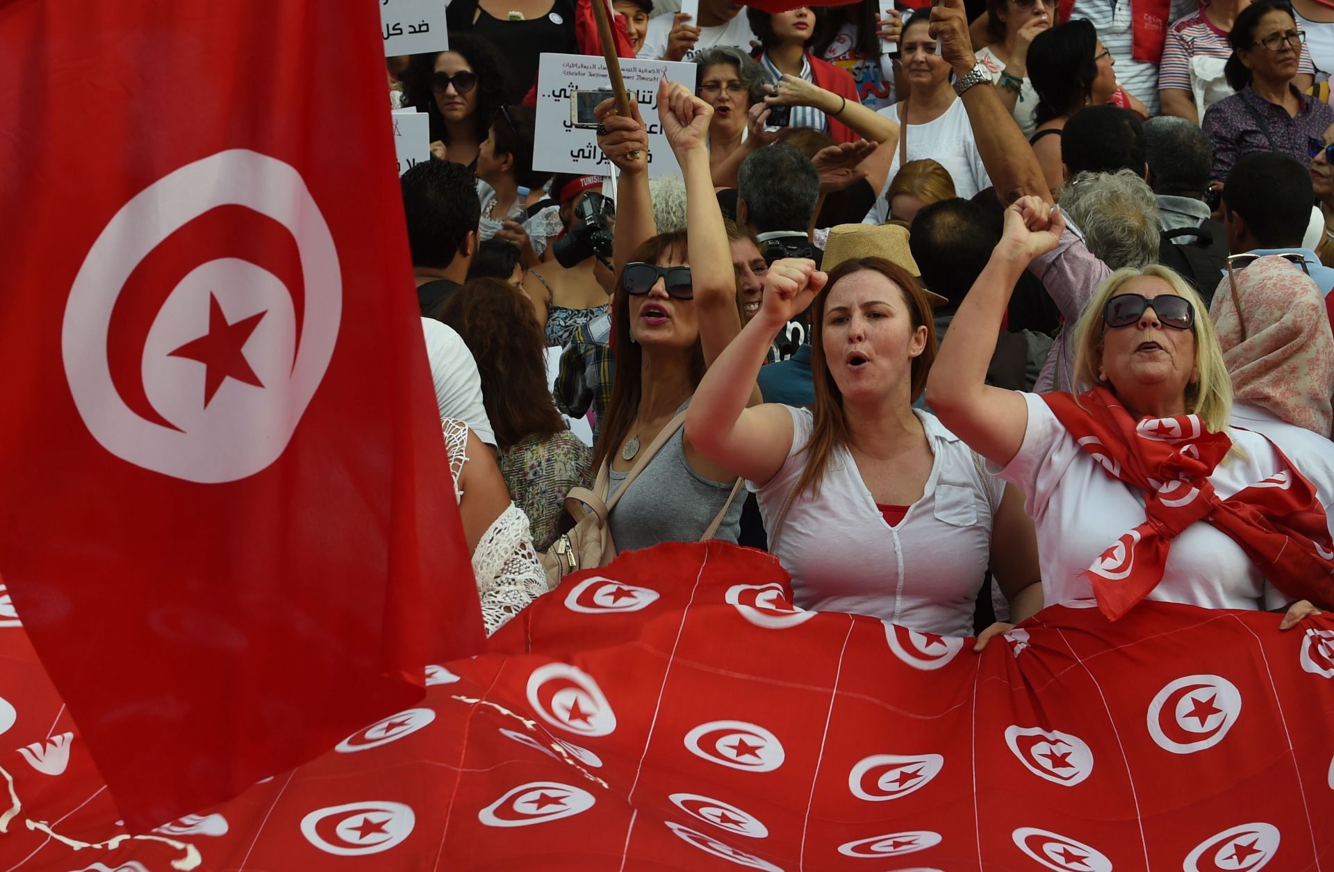 Tunisian women chant slogans and wave their national flag during a demonstration on Aug. 13, 2018, to mark Tunisia's Women's Day and to demand equal inheritance rights for men and women.