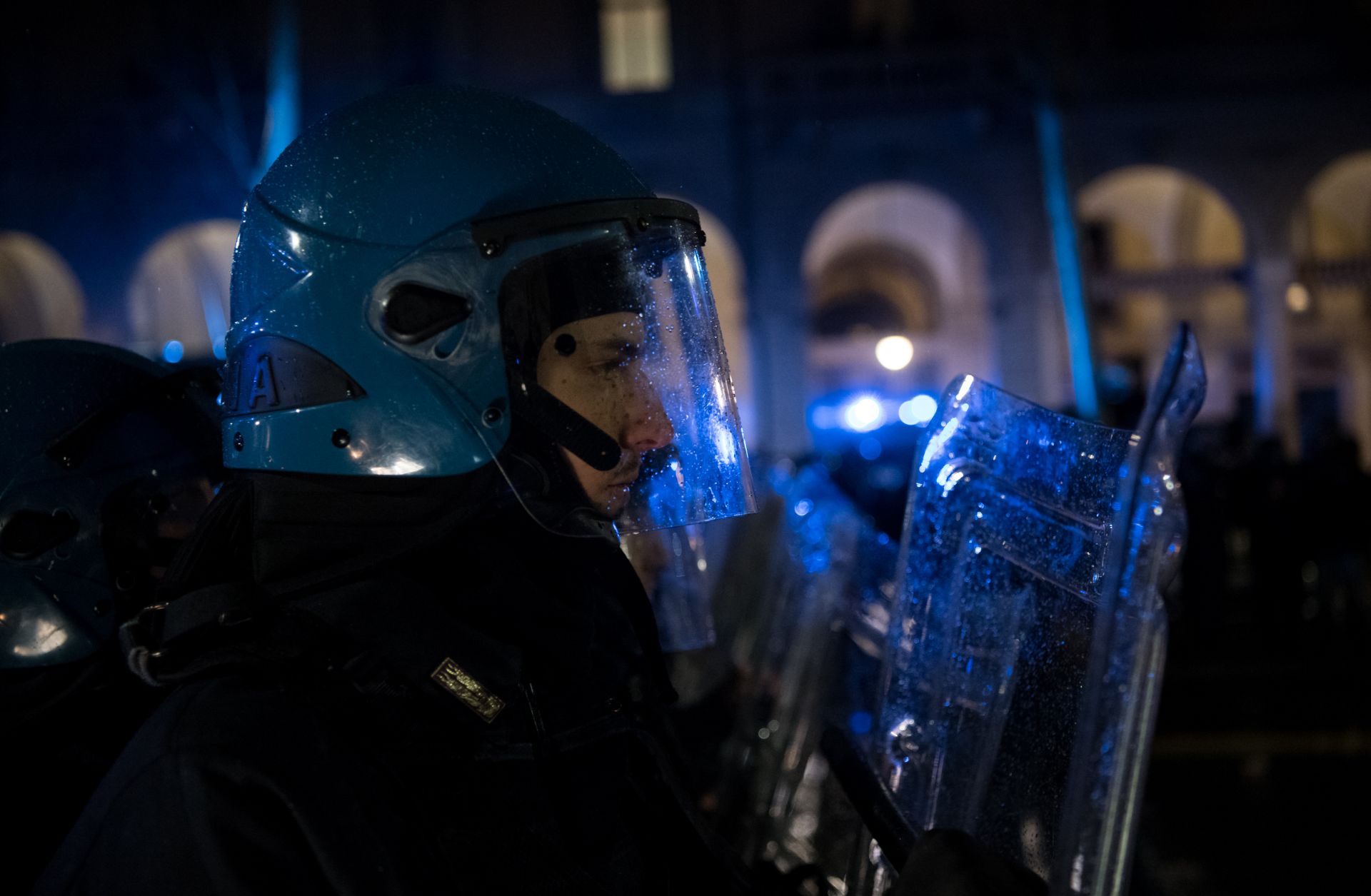 An Italian police officer in riot gear watches an anti-fascist counterdemonstration against a far-right meeting. 