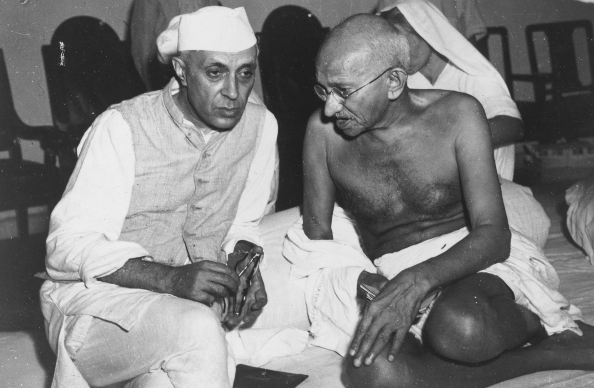 Jawaharlal Nehru (left) and Mohandas K. Gandhi talk at a committee meeting in Bombay.