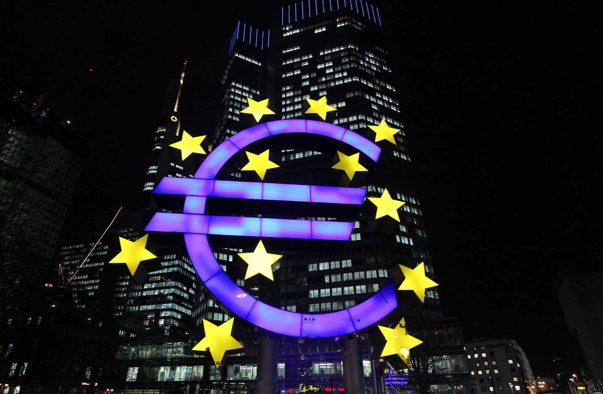 The illuminated sculpture by German artist Ottmar Hoerl's depicting the Euro is seen in front of the European Central Bank.