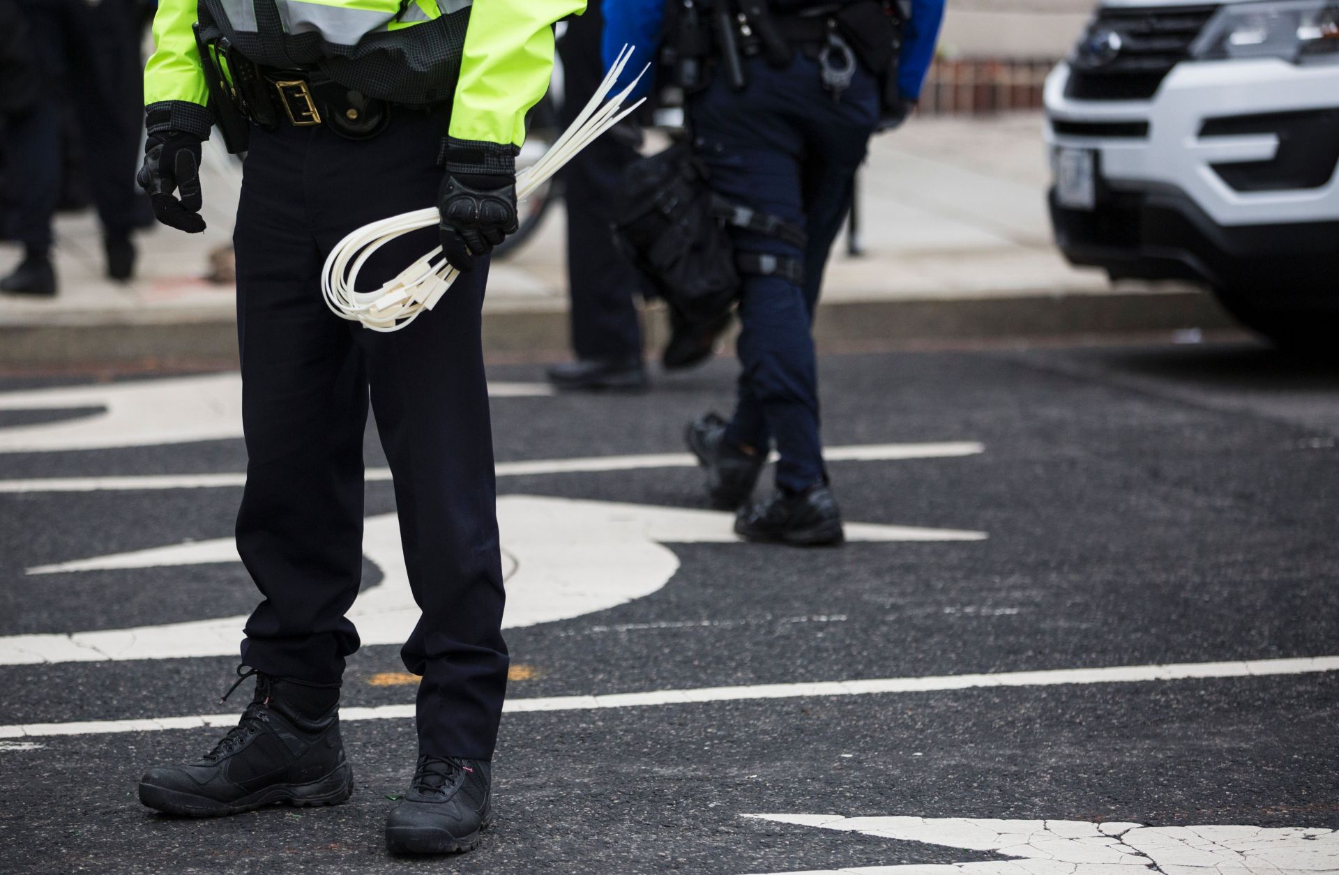 A police officer stands holding zip ties during a protest before the inauguration of U.S. President Donald Trump. 