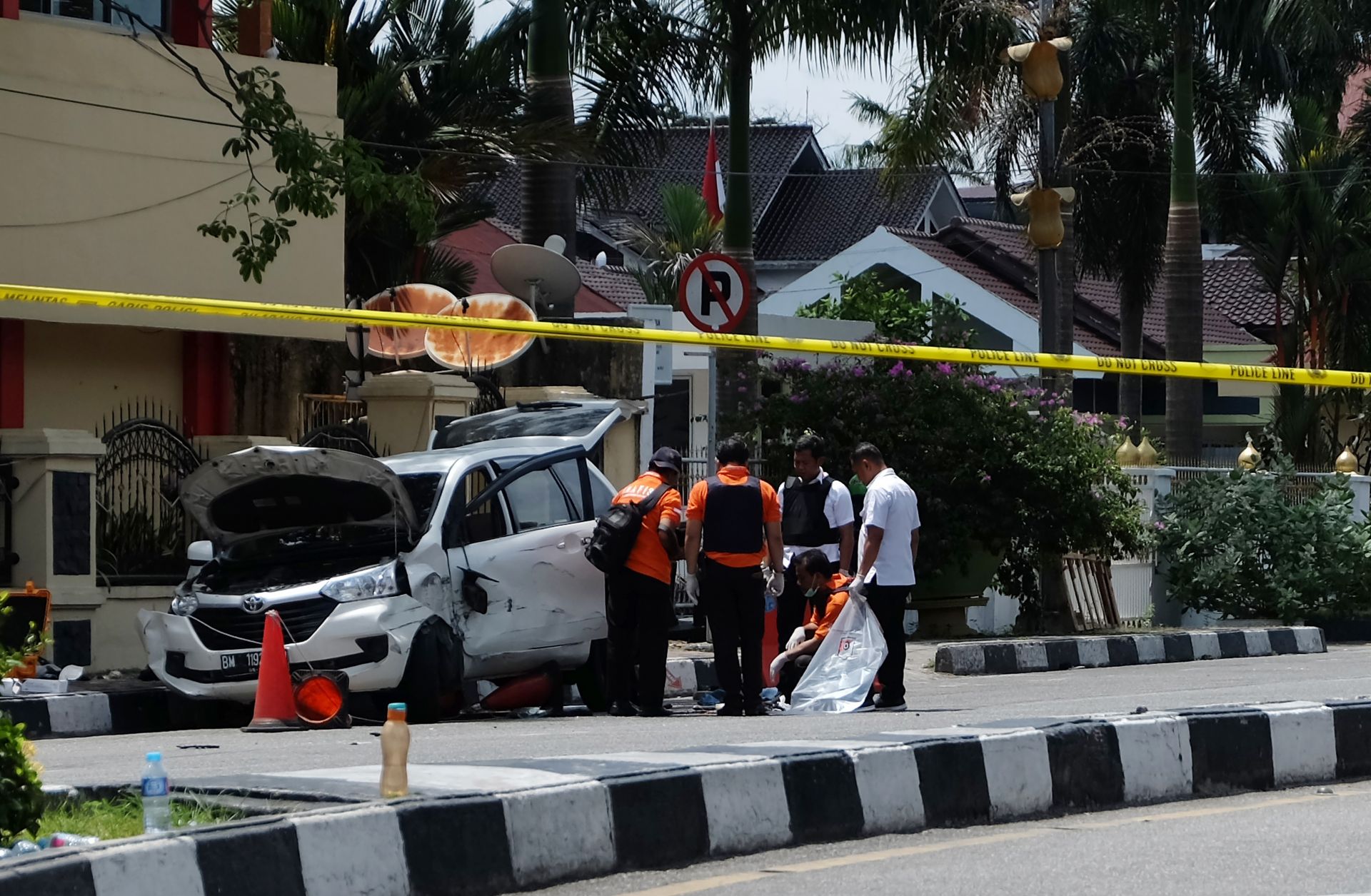 In this photograph, police in Indonesia examine a minivan used five men to attack a police headquarters in Pekanbaru, Riau, on May 16, 2018.