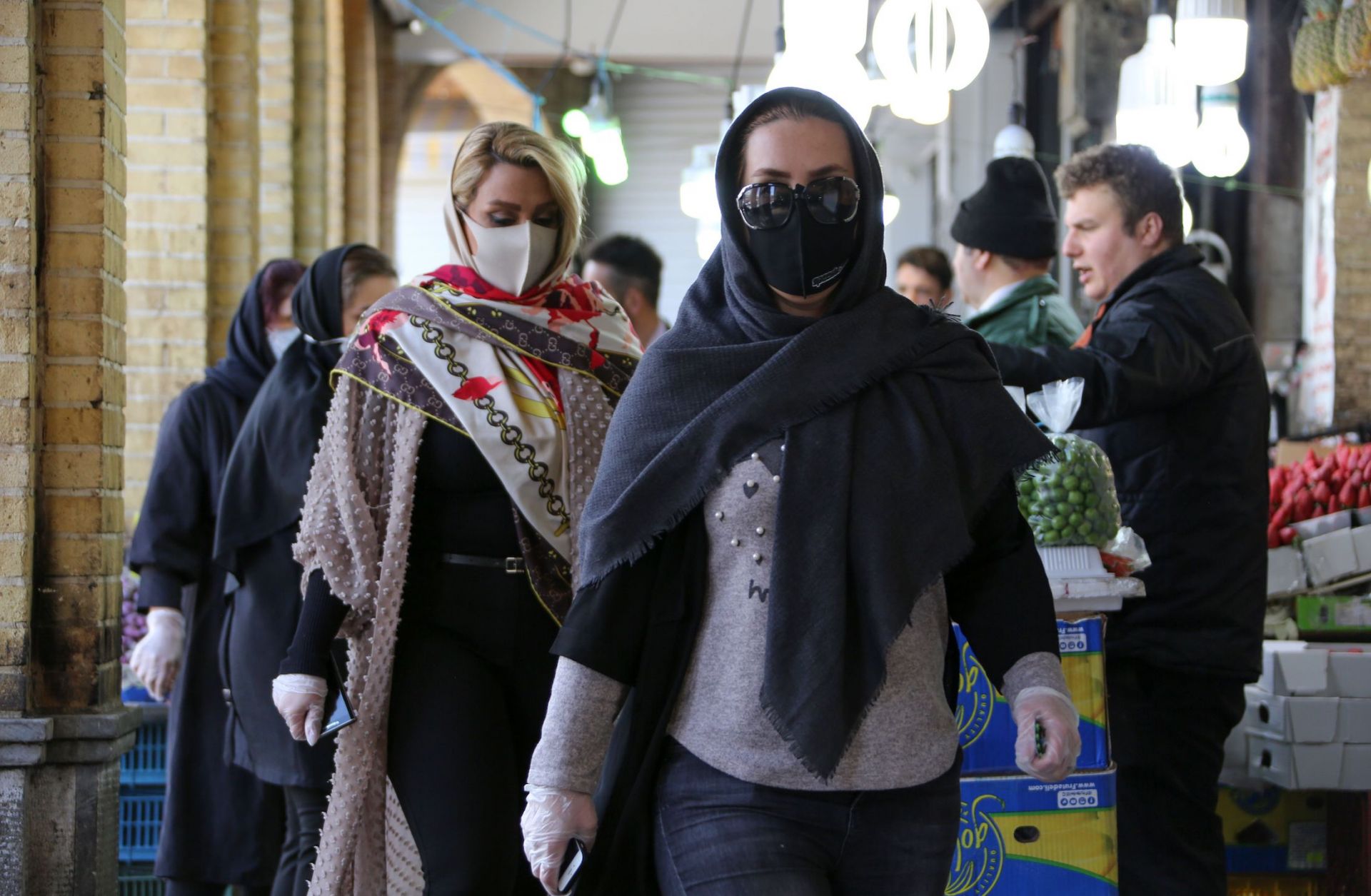 Shoppers wear protective face masks in a bid to prevent the spread of COVID-19 in a market on April 5, 2020, in the Iranian capital of Tehran. 