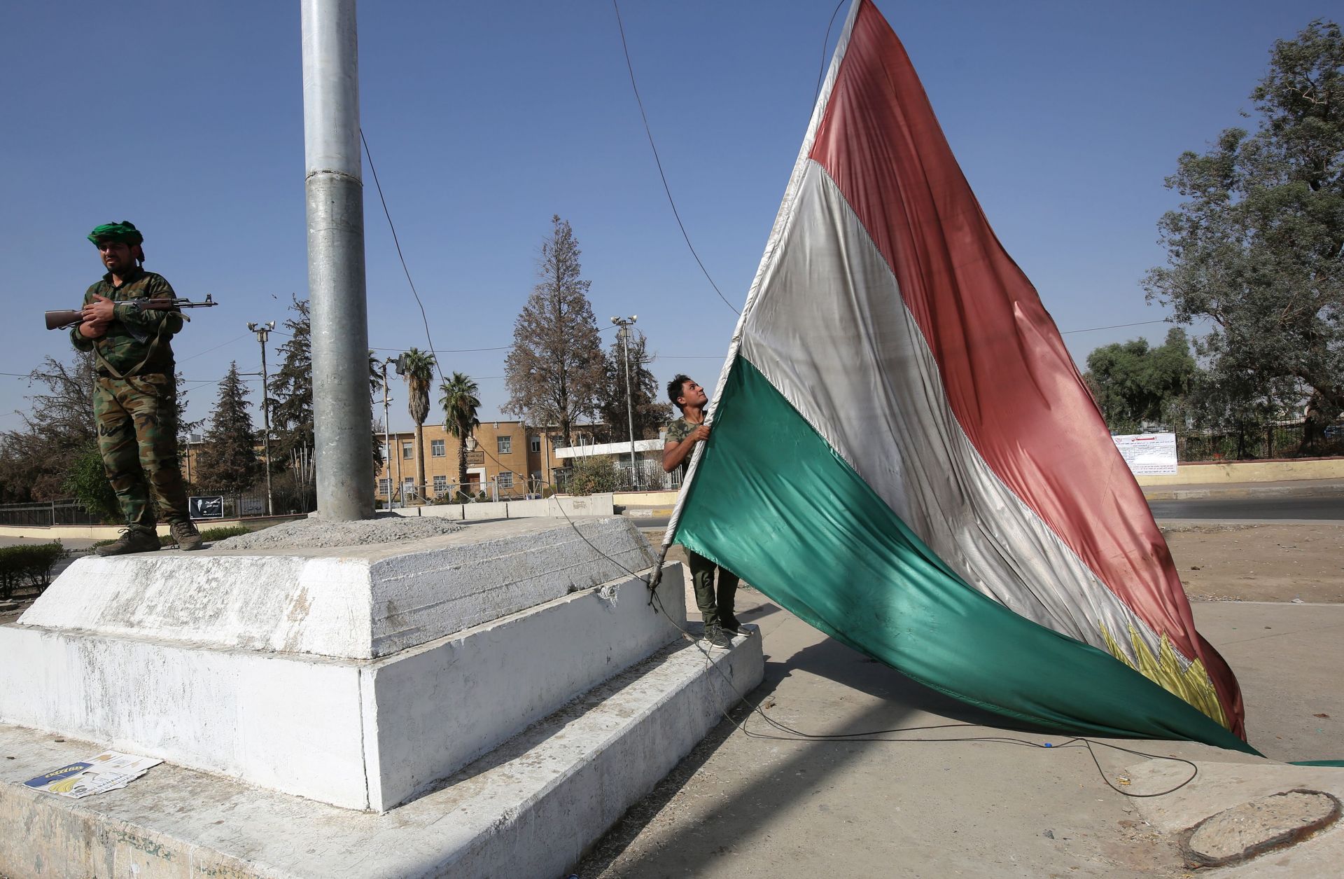 A member of the Iraqi security forces takes down a Kurdish flag in Kirkuk on Oct. 16, 2017. 