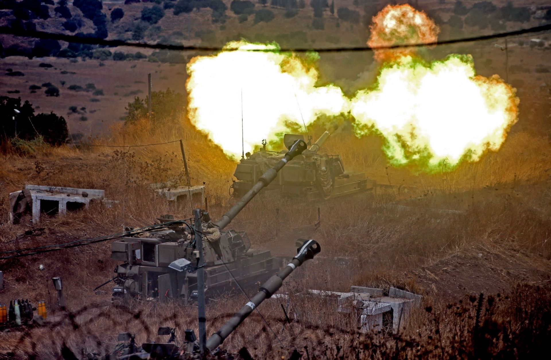 Israeli self-propelled howitzers fire toward Lebanon on Aug. 6, 2021, from a position near the northern Israeli town of Kiryat Shmona following rocket fire from the Lebanese side of the border.