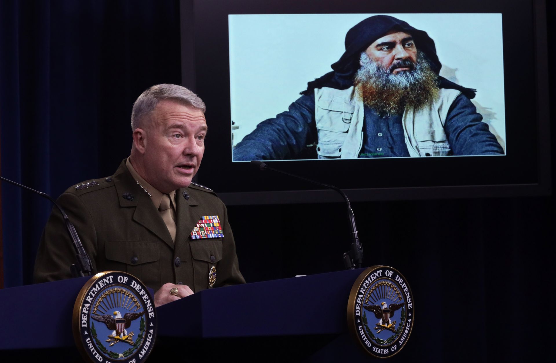 U.S. Marine Corps Gen. Kenneth McKenzie speaks as a picture of Abu Bakr al-Baghdadi is seen during a press briefing Oct. 30, 2019, at the Pentagon in Arlington, Virginia.