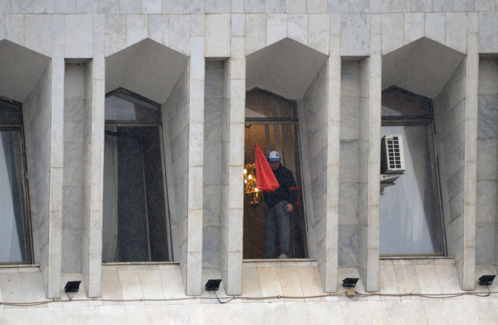 A protester is seen in the window of the seized main government building, known as the White House, in Bishkek, Kyrgyzstan, on Oct. 6, 2020. 